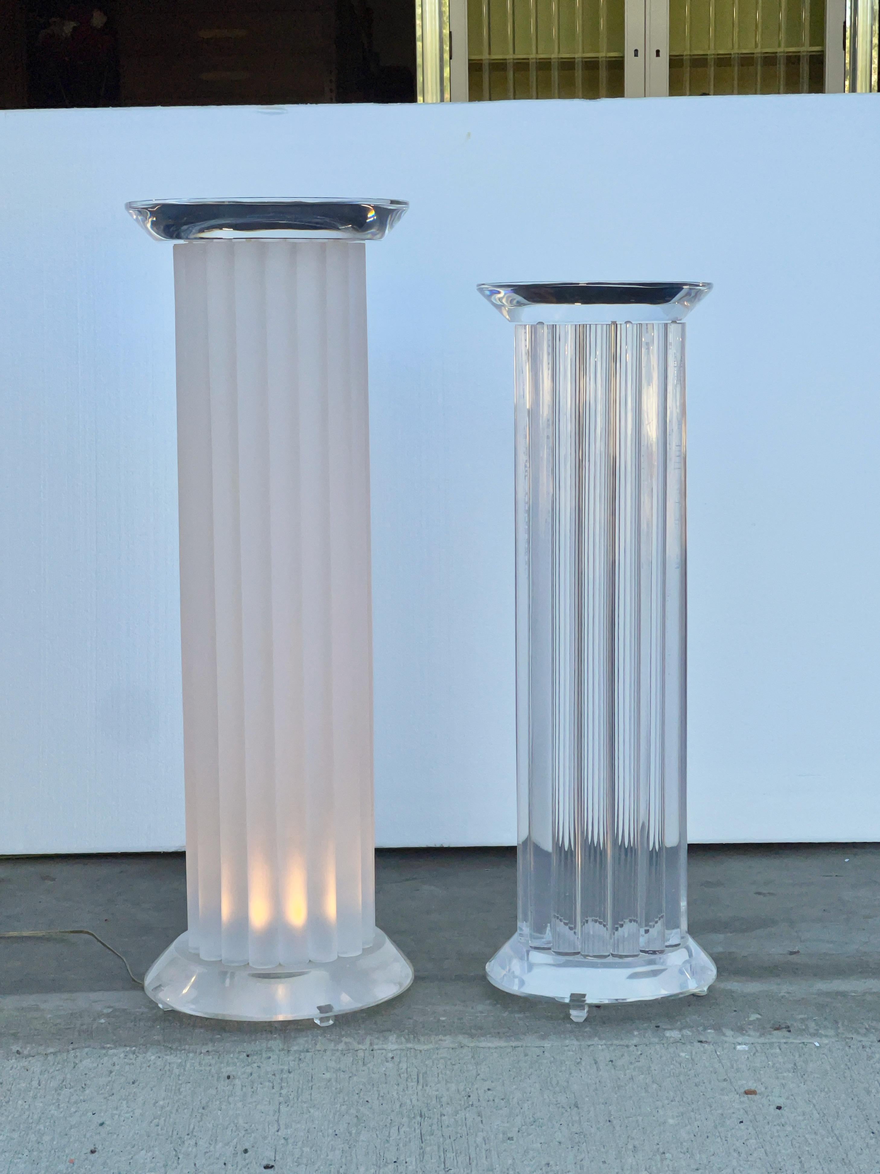 Two custom fabricated lucite pedestal columns both with ~2” thick lucite tops and bases with beveled edge.
The columns themselves are made up of 17 vertical round rods approx 1.5” diameter.
The taller is fitted with a lighting element in the base