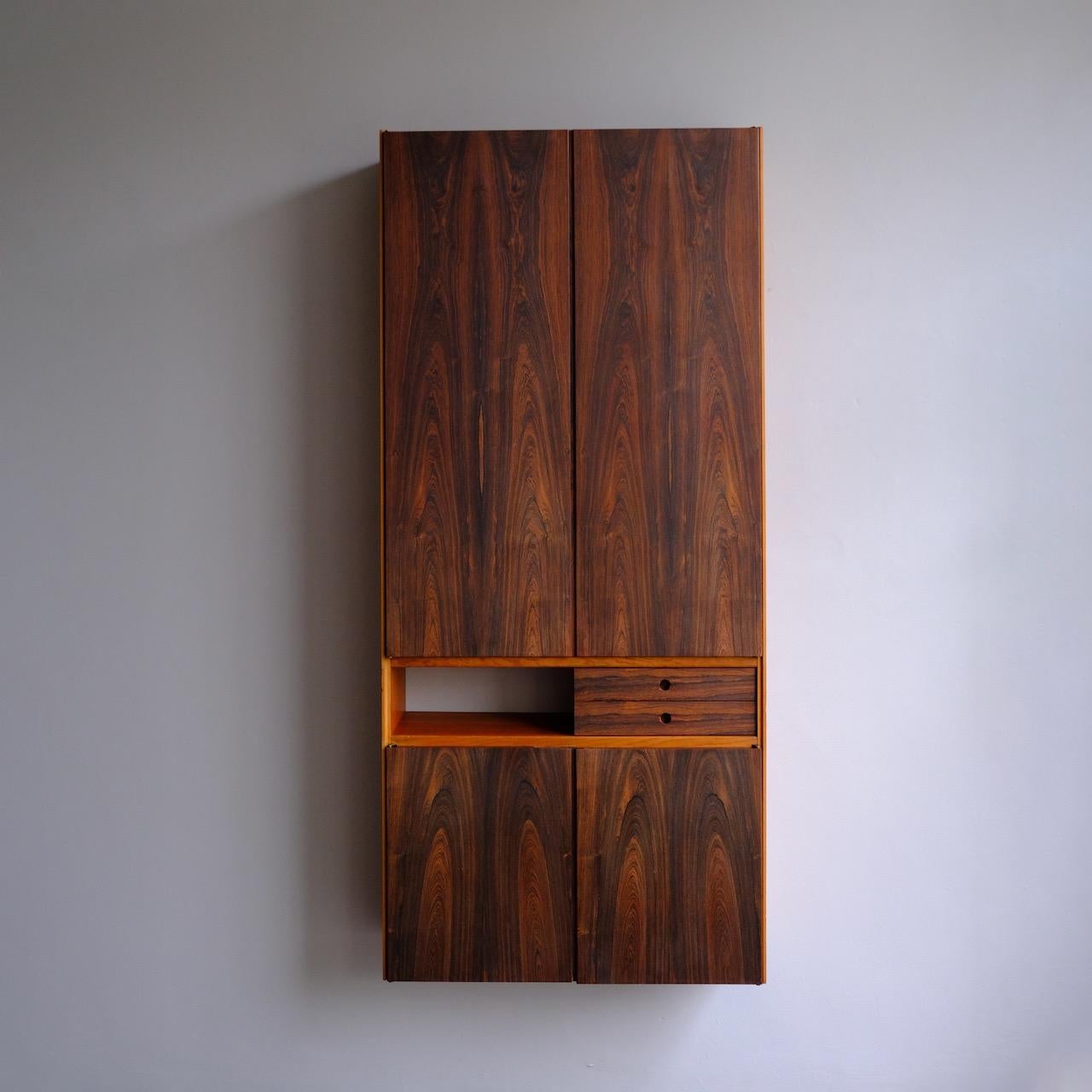 A pair of large wall mounted cabinets of unusual proportions and excellent construction, made in Denmark circa 1960. 

Both the top and bottom halves of each cabinet are fitted with double doors. The exquisitely grained mahogany fronting these