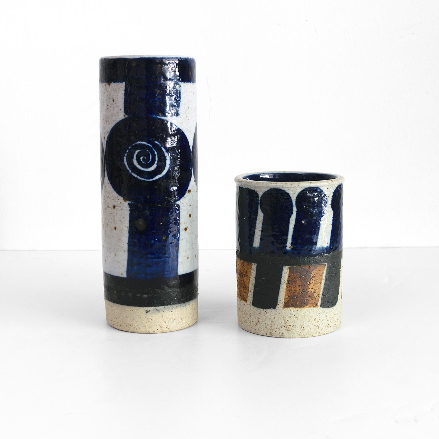 Two Inger Persson studio ceramic vases with hand applied abstract decoration. A signature use of bold blue and black strokes on a white partially glazed stoneware. Make at Rorstrand, Sweden, circa 1960.
Measures: Height: 10.5”. Diameter: 4” &