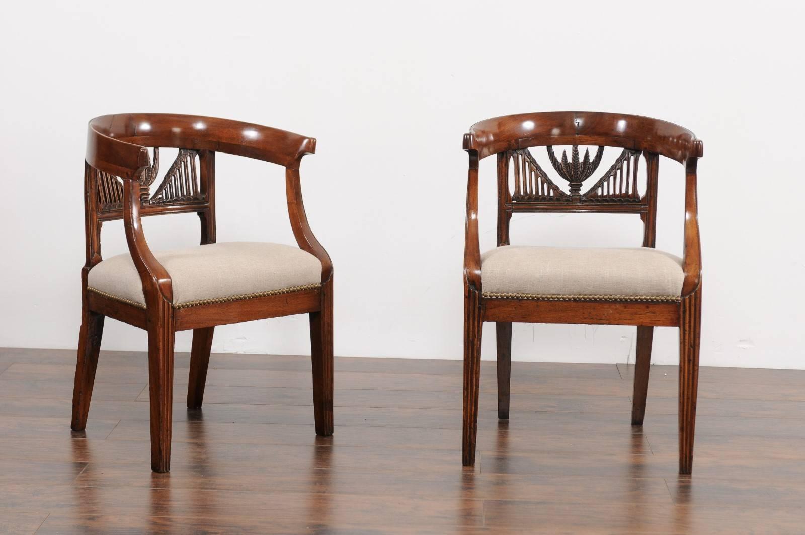 Two Italian walnut armchairs from the early 19th century with pierced splats, wraparound backs and new upholstery, priced and sold individually. Each of these Italian walnut armchairs features an exquisite wraparound back, adorned with an