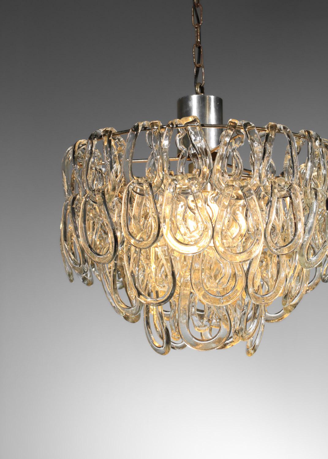 Coppia di lampade a sospensione italiane degli anni '70 di Angelo Mangiarotti. Struttura del lampadario in metallo cromato, pendenti in vetro di Murano trasparente. La forma dei ciondoli può essere modificata grazie ai ciondoli indipendenti.
