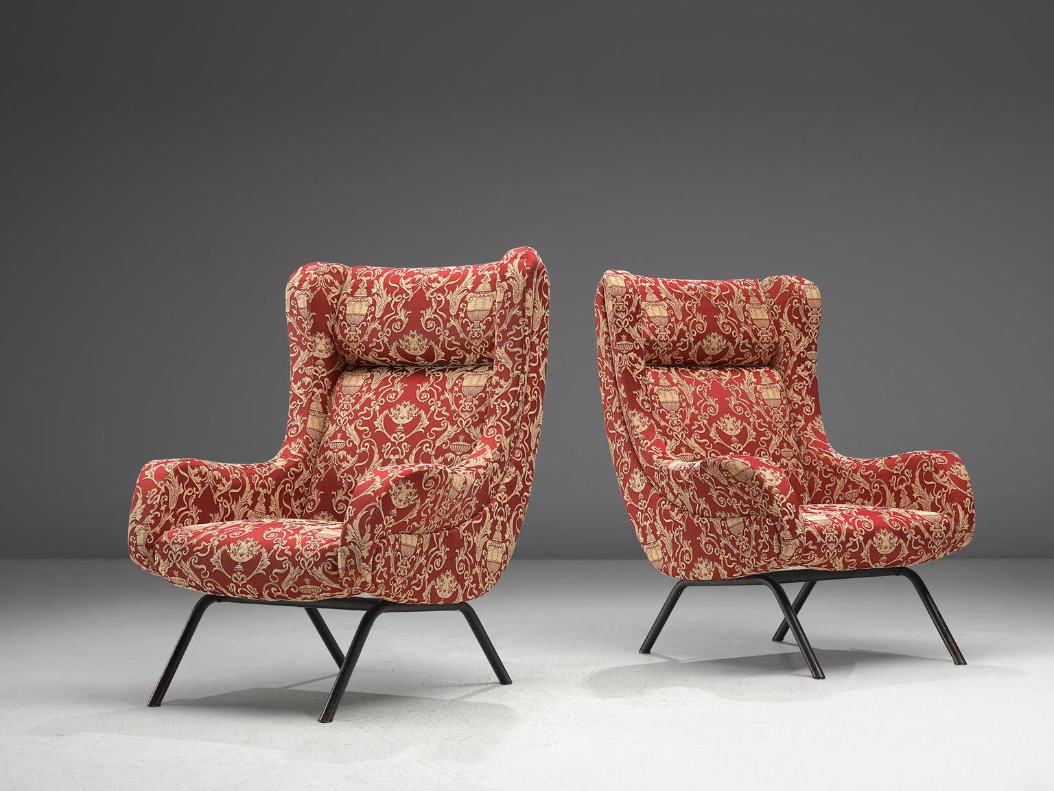 Lounge chairs, original red fabric and brass, Italy, 1950s. 

These chairs are iconic examples of Italian design from the fifties. Organic and sculptural, these easy chairs are anything but minimalistic. Equipped with the original stiletto brass