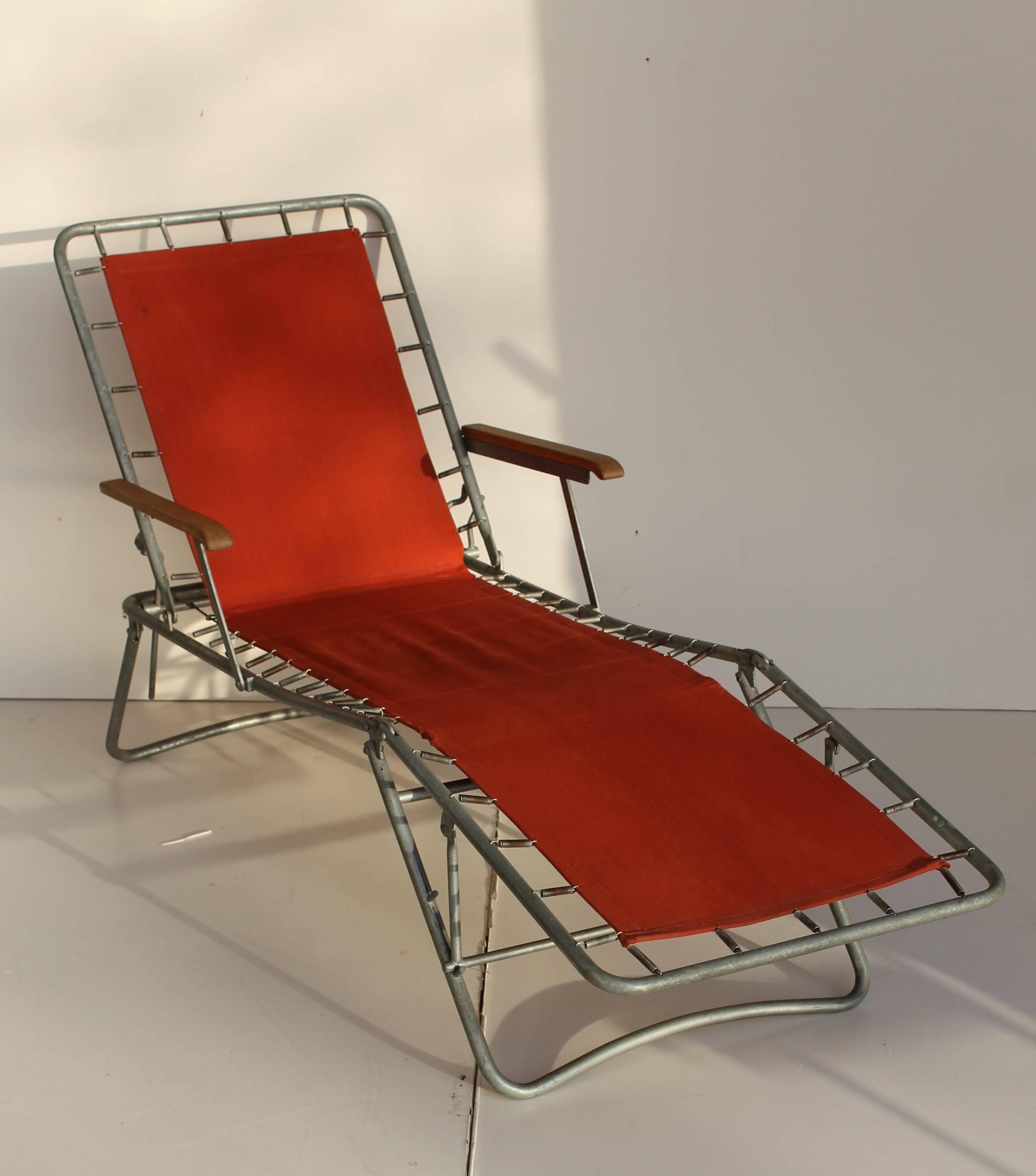Two loungers, made in Italy, dated circa 1950.

Metal tubular structure, brick red canvas holds by a springs frame (see detailed pictures). Wood armrests.

Very good original conditions.

A third lounger is available.