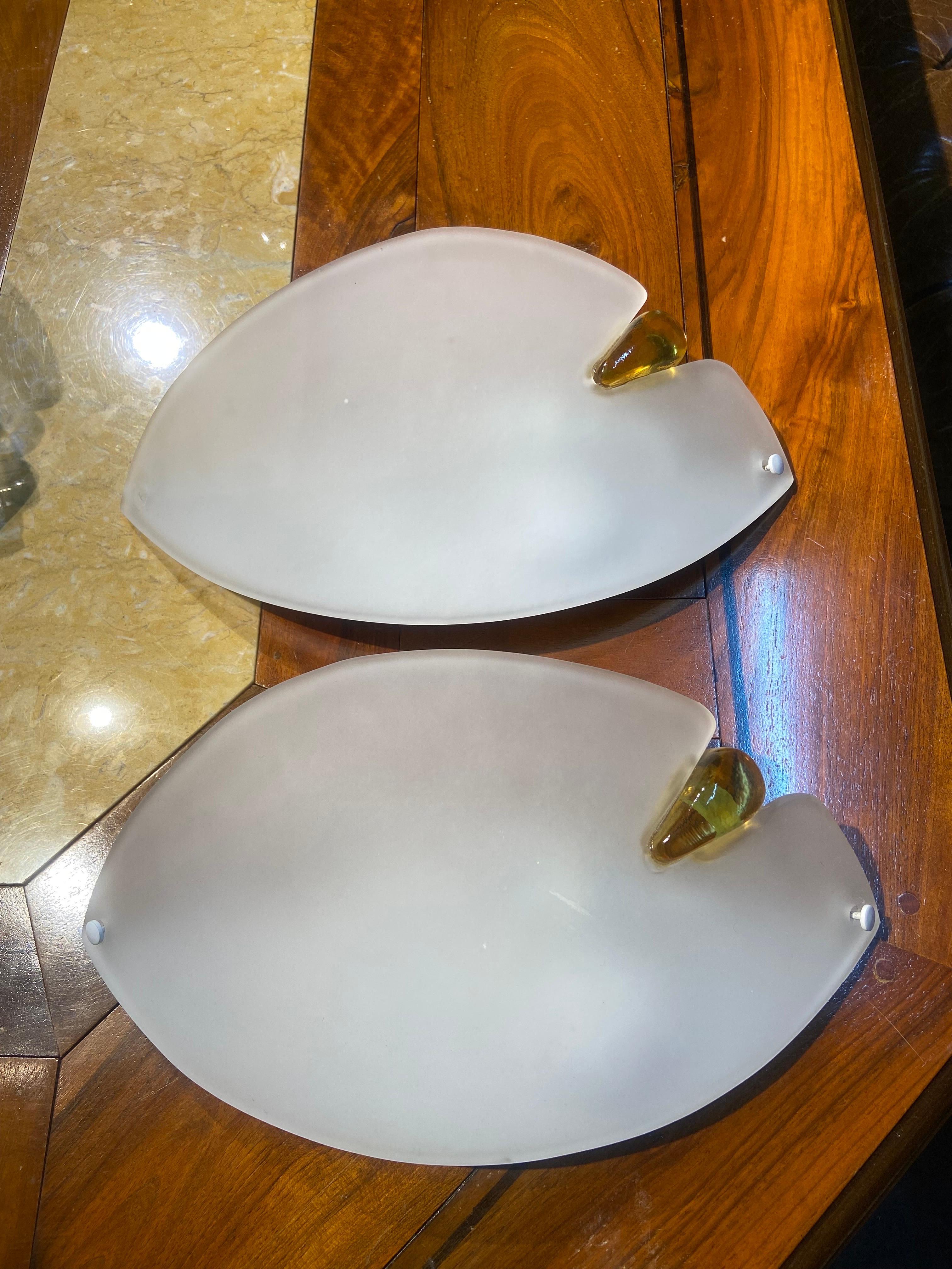 Two Italian modern wall lamps AV Mazzega made of hand-crafted Murano glass with satin finish in eye shape with yellow side decoration.
Founded in 1946 by Gianni Bruno Mazzega, the company AVMazzega brings centuries of experience and craftsmanship,