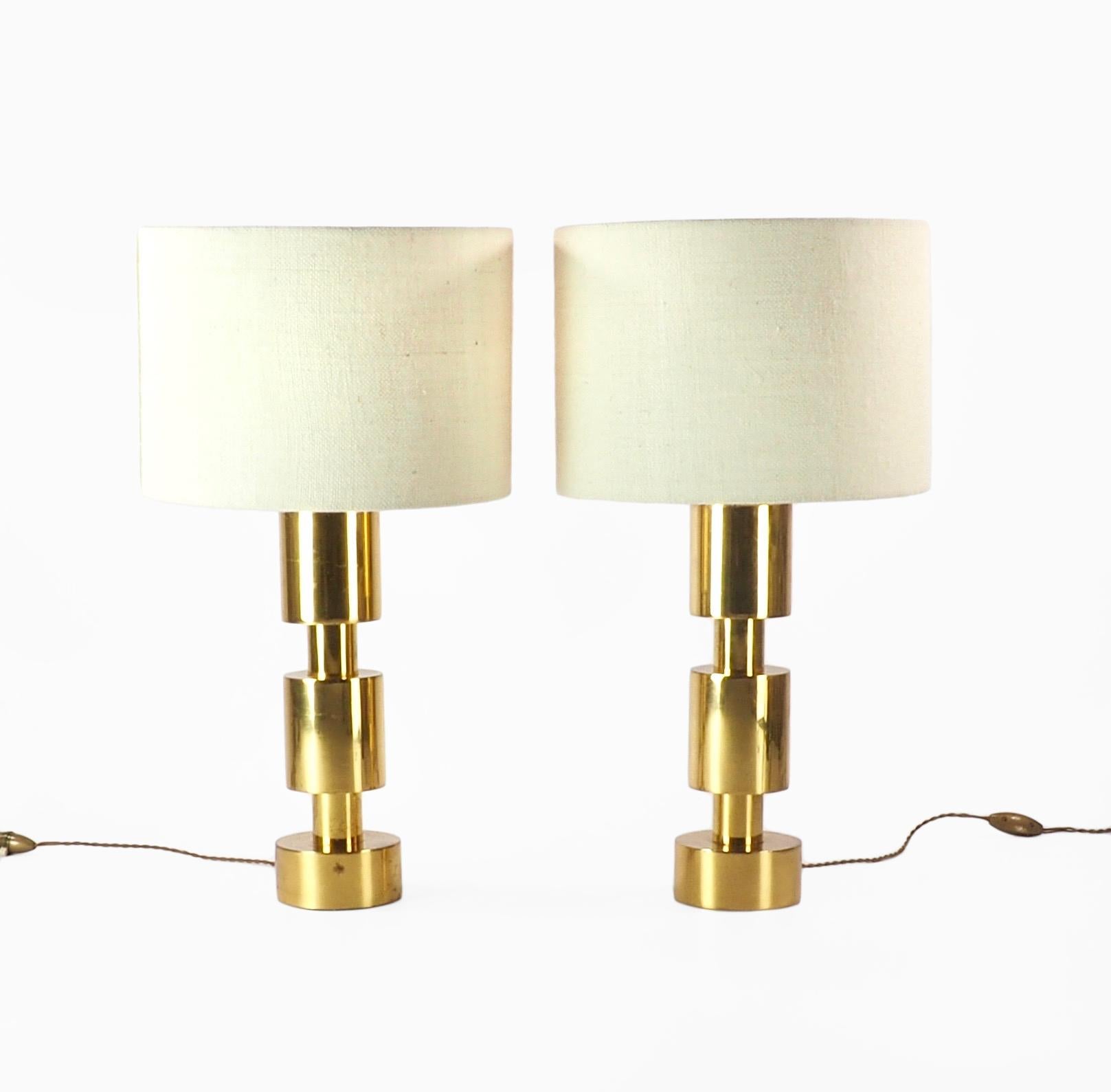 A pair of stylish Italian gilded metal segmented cylinder table lamps of Minimalist 1970s design. Finished with subtle drum shaped pale hessian shades. slight crazing and oxidation to metal. Dimensions; Lamps: H 43.5 x D 9 cm. Shades: H 23 x D 32 cm.