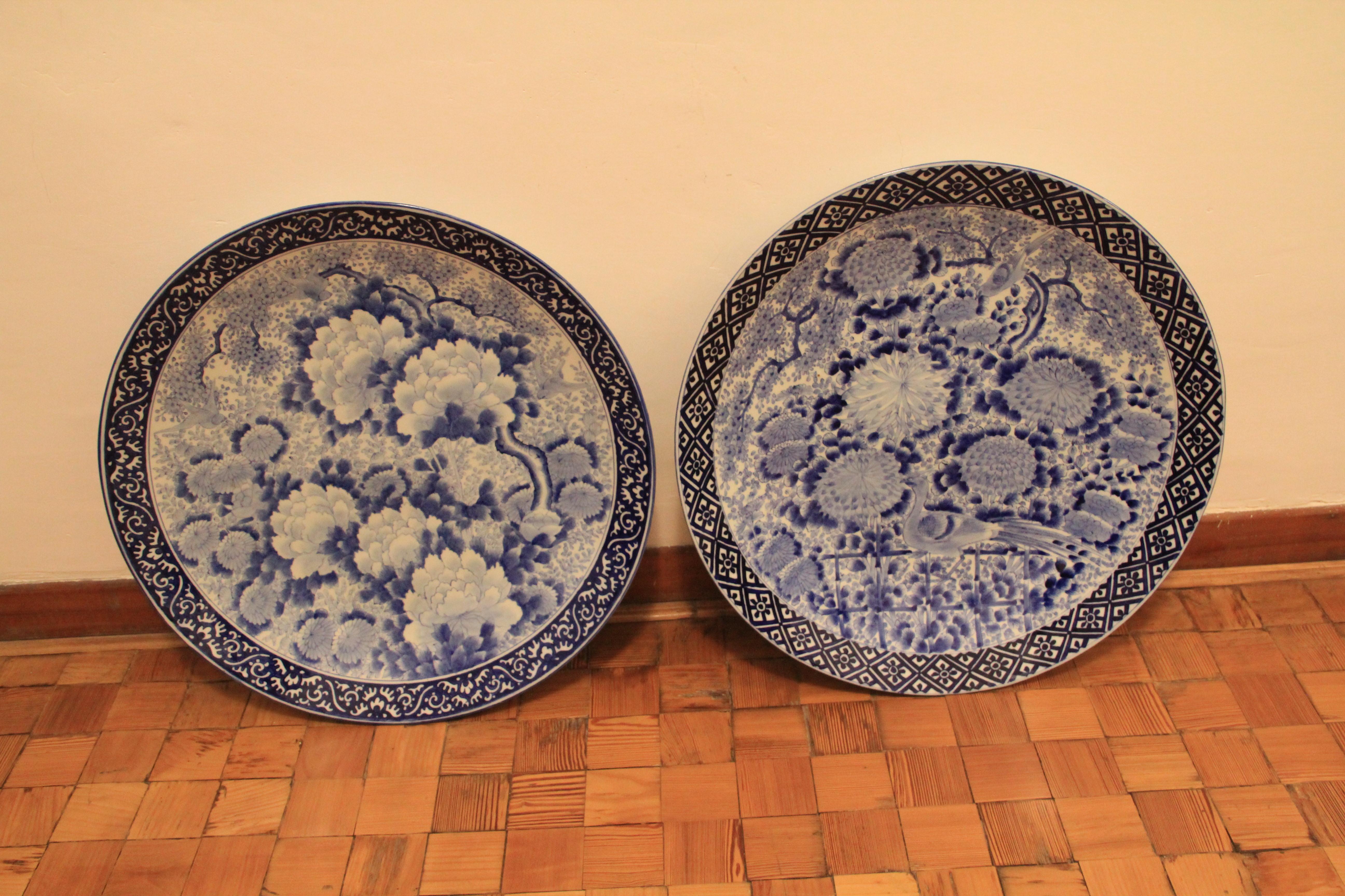 Two large Japanese dishes decorated in underglaze blue with chrysanthemum and bird pattern centres and geometric motif borders, these were made in Japan in the late 19th-early 20th century.
Measure: 56 cm width, 7.5 cm height.