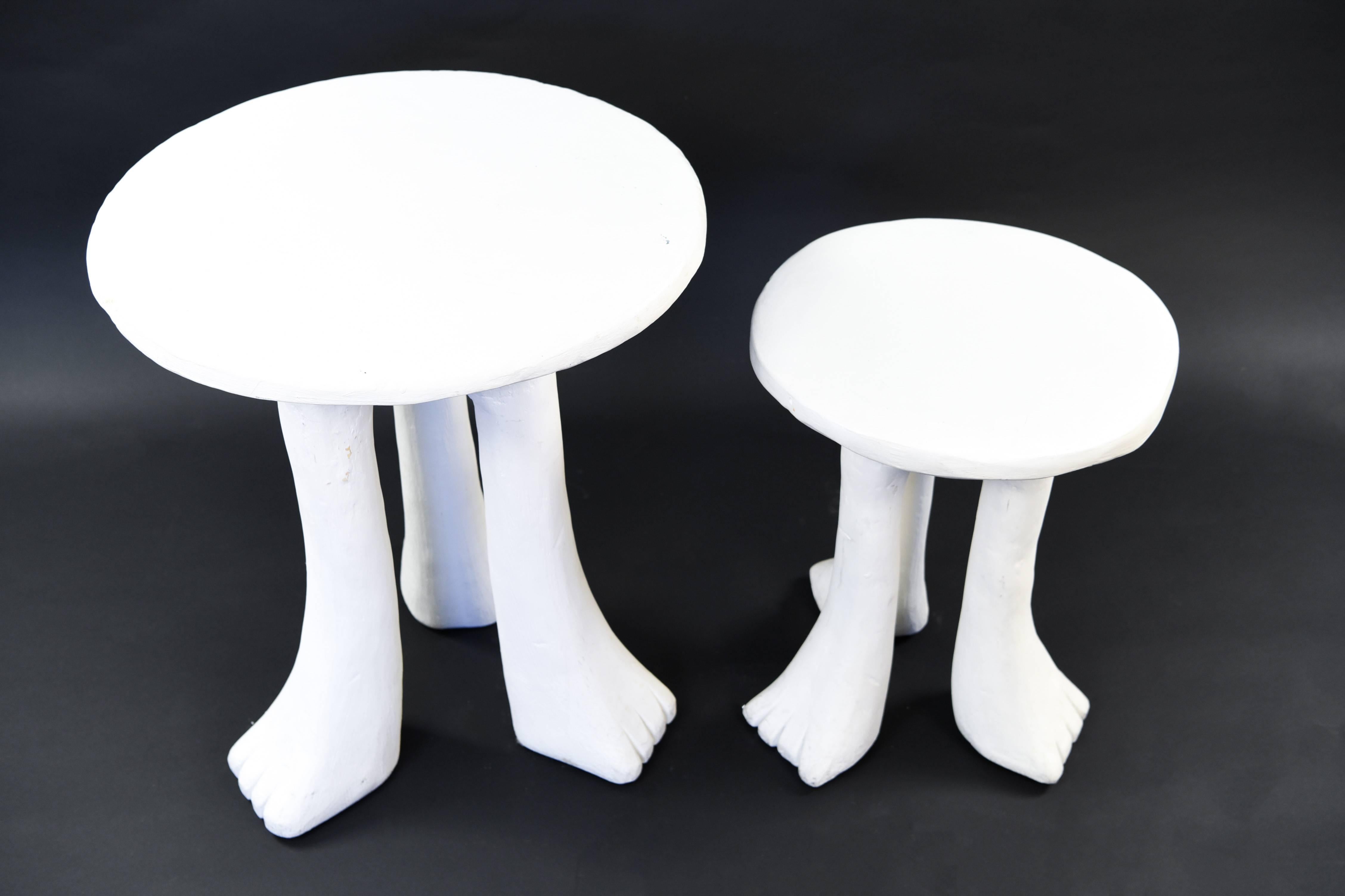 Two iconic John Dickinson plaster and gesso three-legged Africa tables of different sizes, circa 1970s. A fun, whimsical example of Dickinson's work, these tables feature animal paw feet that extend from three legs. These playful pieces combine