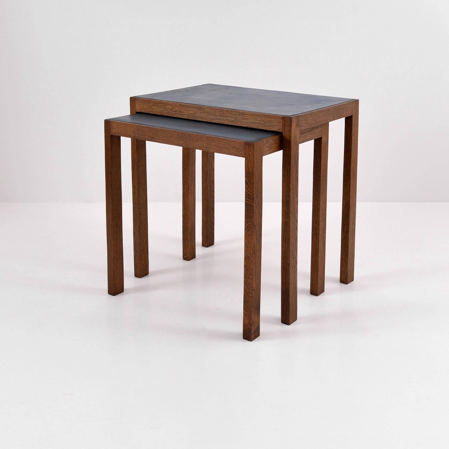 Two large Bauhaus nesting tables in stained oak and linoleum surface, Germany, circa 1930.