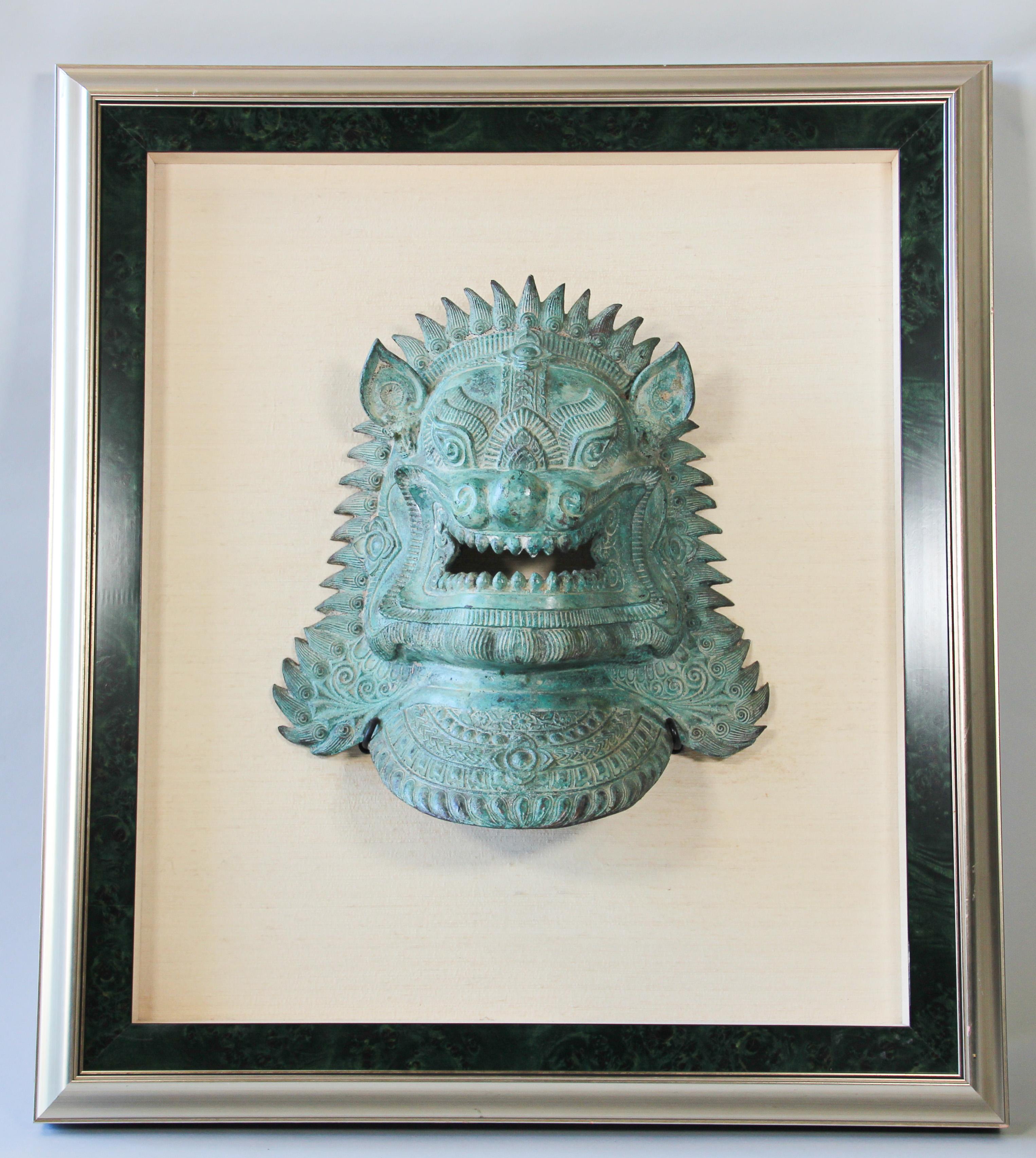 Two large Khmer style foo dogs dragon masks mounted and framed.
Featuring a pair of highly detailed stylized metal bronze lions mask sculptures, one male and one female which were thought to protect the home from harmful spiritual influences and