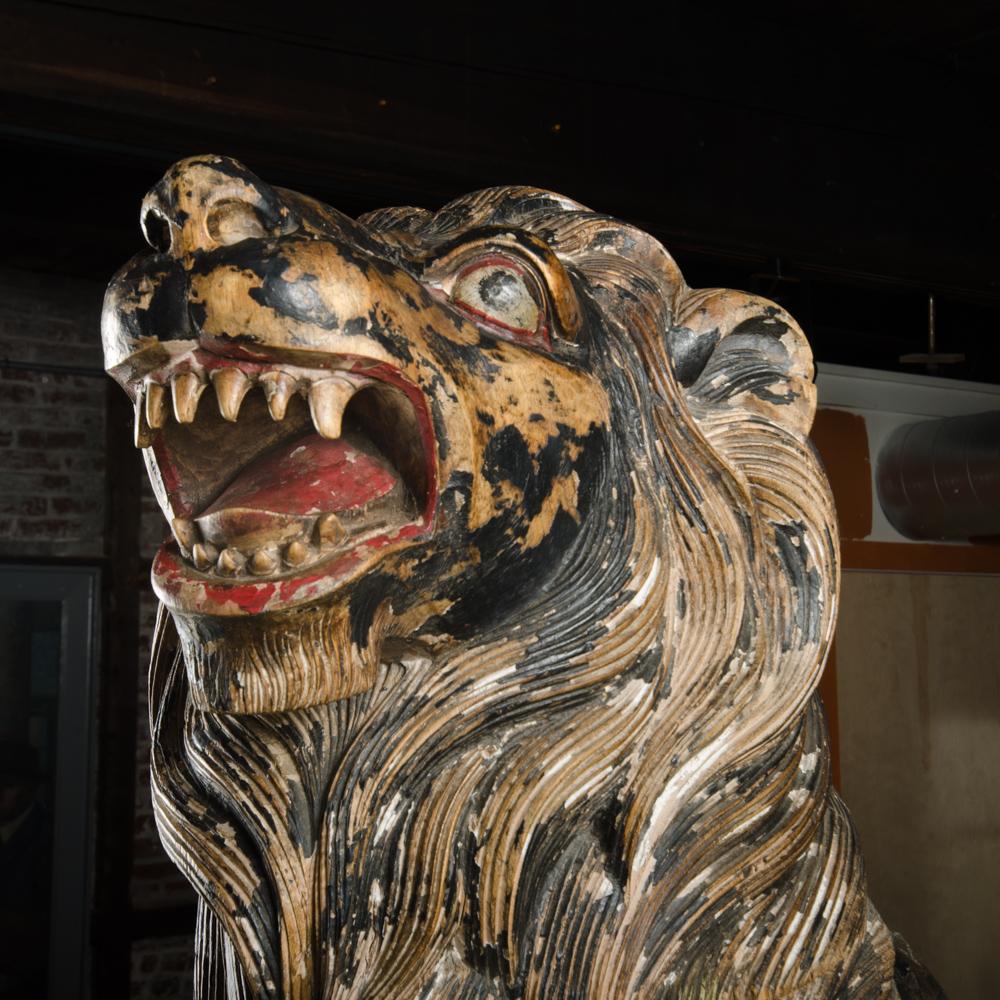 Two large life sized polychromed lion head wooden statues. Knockdown. C 19th century continental Europe.