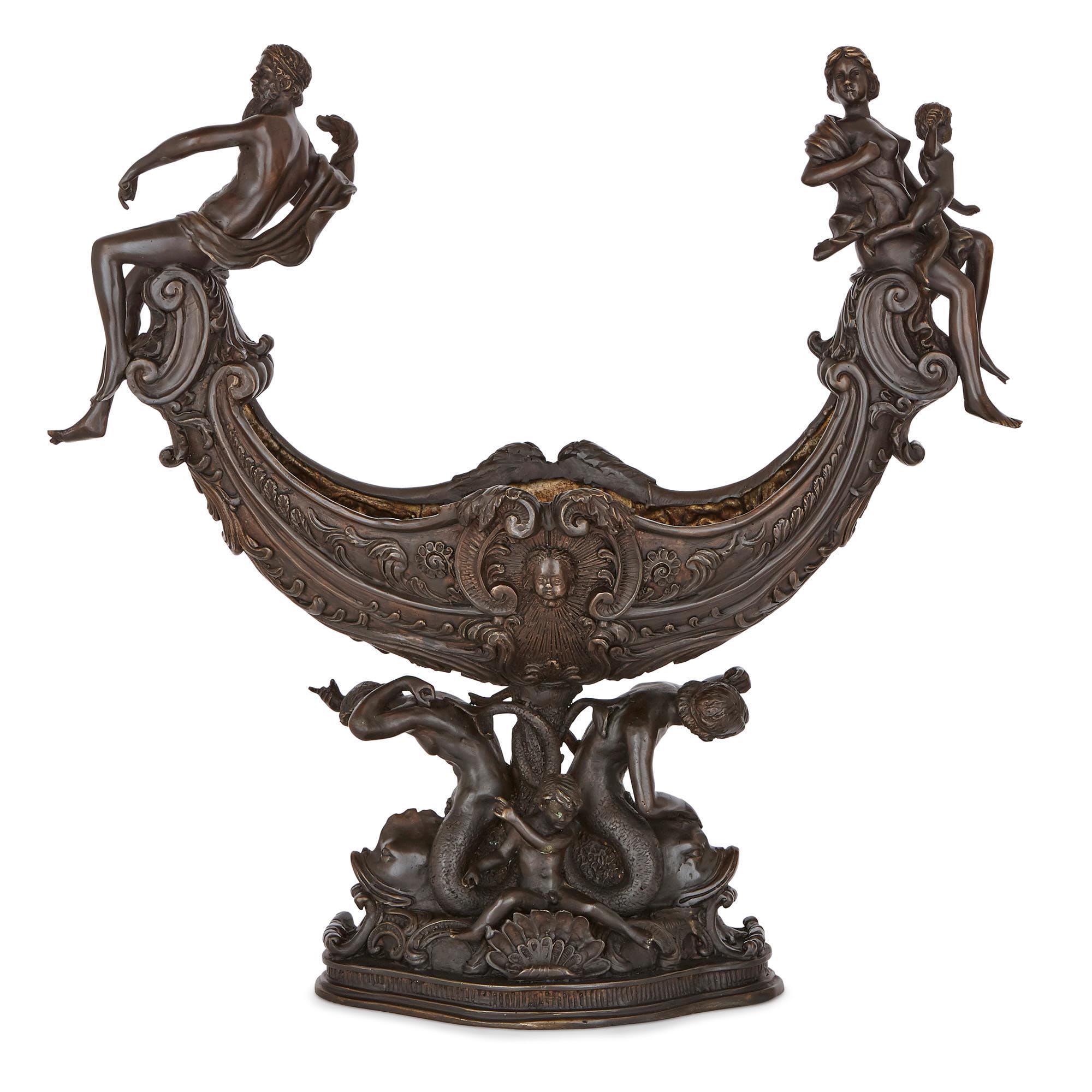 This centrepiece garniture was crafted in the 19th Century in Italy. The two bronzed metal items are identically designed, in an expressive and classically-inspired late Renaissance style. 

The items take the form of U-shaped, ship-like vessels,