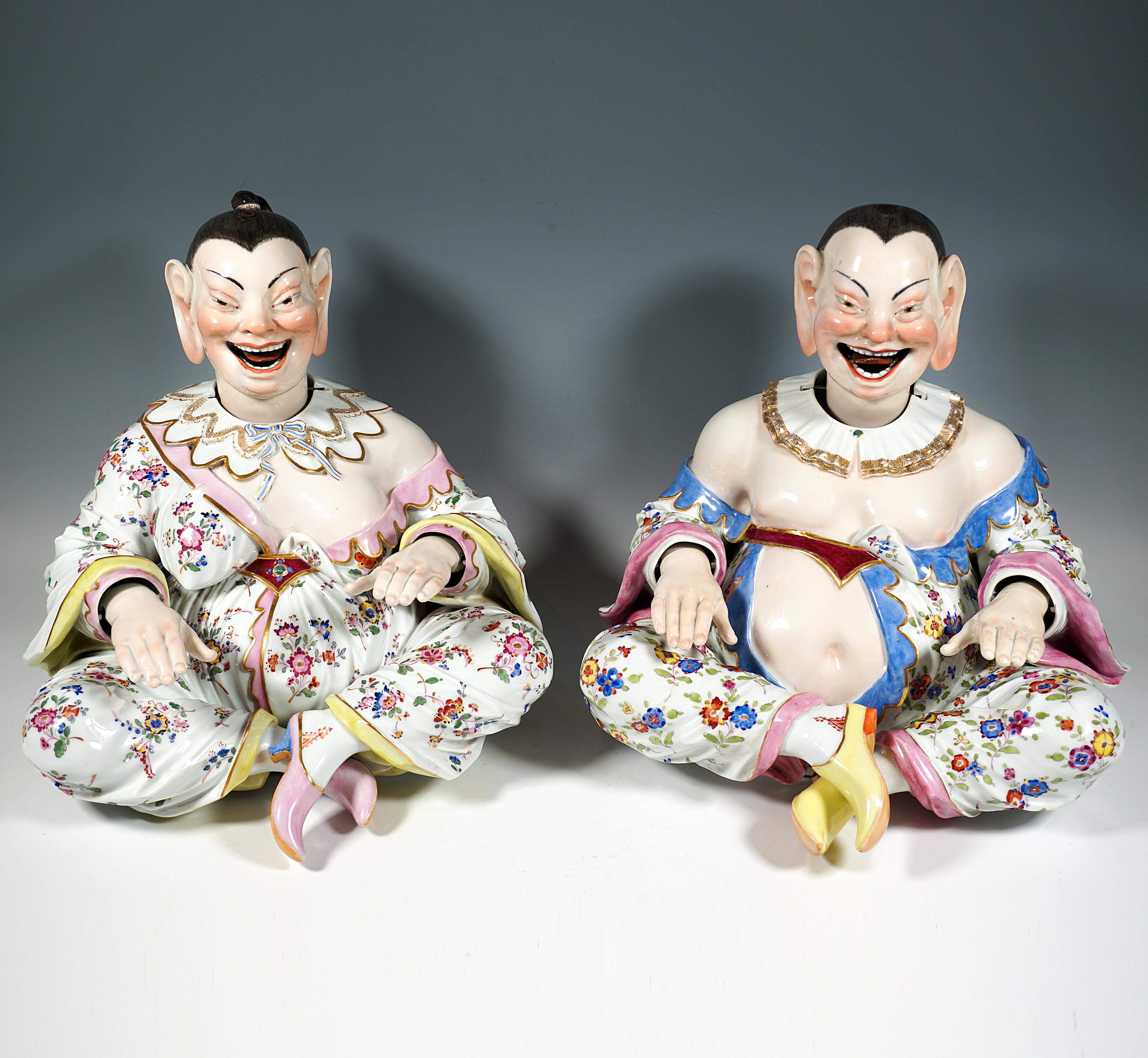 Depiction of two seated, smiling Chinese Buddha figures from a series of folk types:
Voluminous bodies with hair tied back strictly, wearing robes that cling closely to the body, belted below the chest, patterned with Indian floral decorations, with