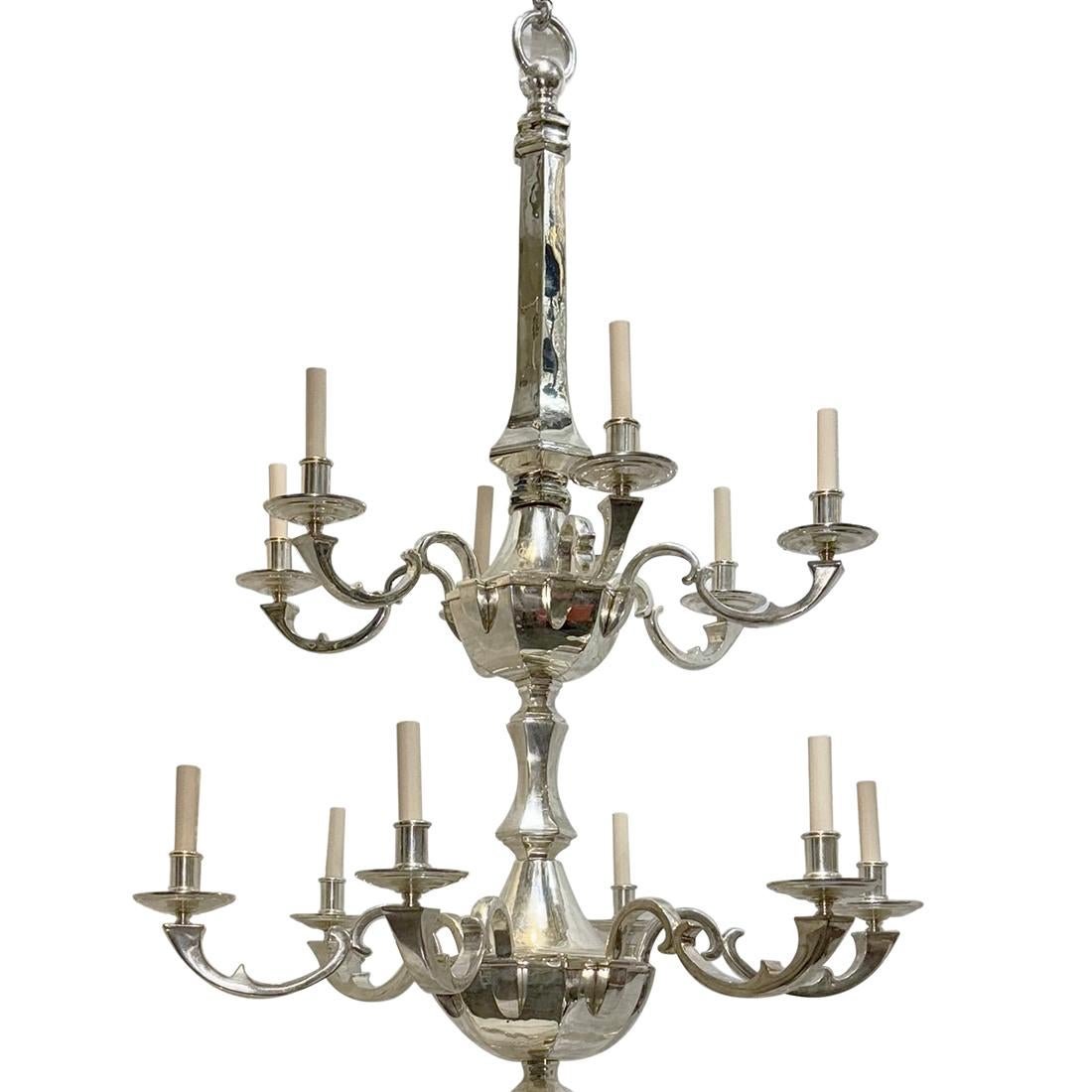 Coppia di grandi lampadari inglesi a tre piani in stile neoclassico placcati in argento, risalenti al 1940 circa, con finiture e patina originali. Ogni livello ha 6 luci ciascuna, per un totale di 18 luci. Venduto singolarmente.

Misure:
Caduta