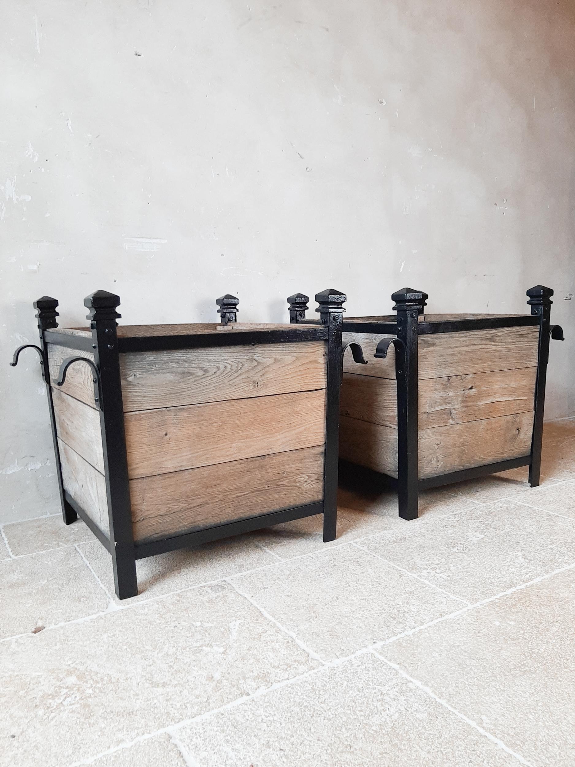 Pair of antique orangery planters. Two large square planters in weathered oak and riveted wrought iron frame and supports, with cast iron corners.

Dimensions: L 77 x W 63 x H 66.5 cm
length x width top of wooden box: 60 x 60 cm.