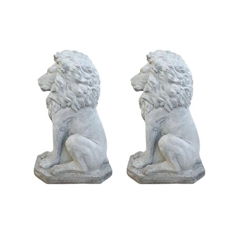 A pair of two cast concrete stone lions. Such a wonderful way to add a regal look to an entryway. (Or perhaps even a driveway.) Each lion sits on its hind legs, with its front paws outstretched and its mane flowing down its back. It stands on a