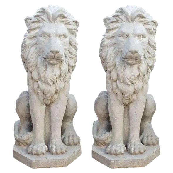 Deux grands lions architecturaux debout en béton, une paire