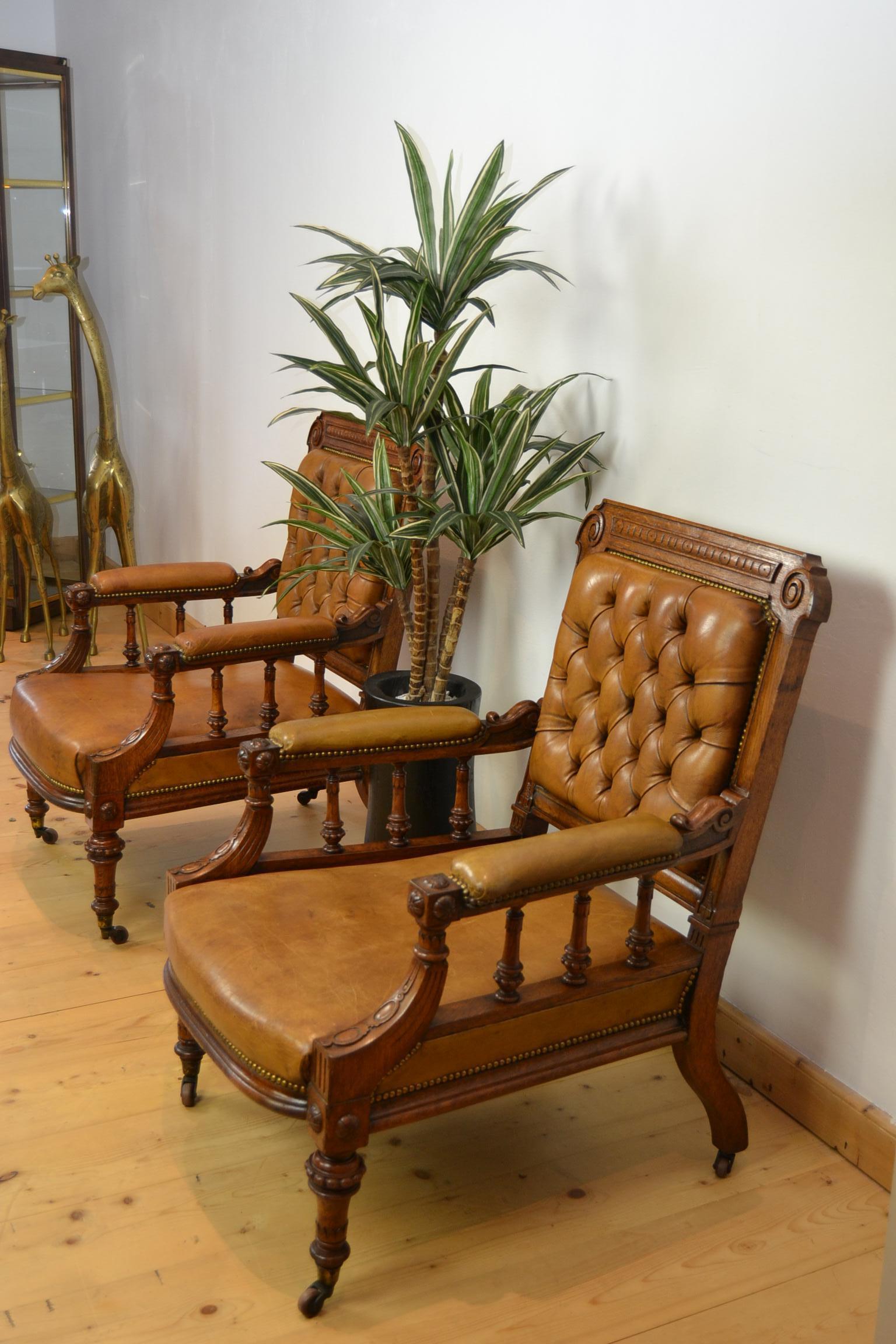 Great looking Antique Library Chairs, Armchairs, Lobby Chairs.
These two Imposing English Chairs with a deep seat , 
date from the late 19th century.
They have a wooden frame and are upholstered in leather.
The back of the chairs have a buttoned
