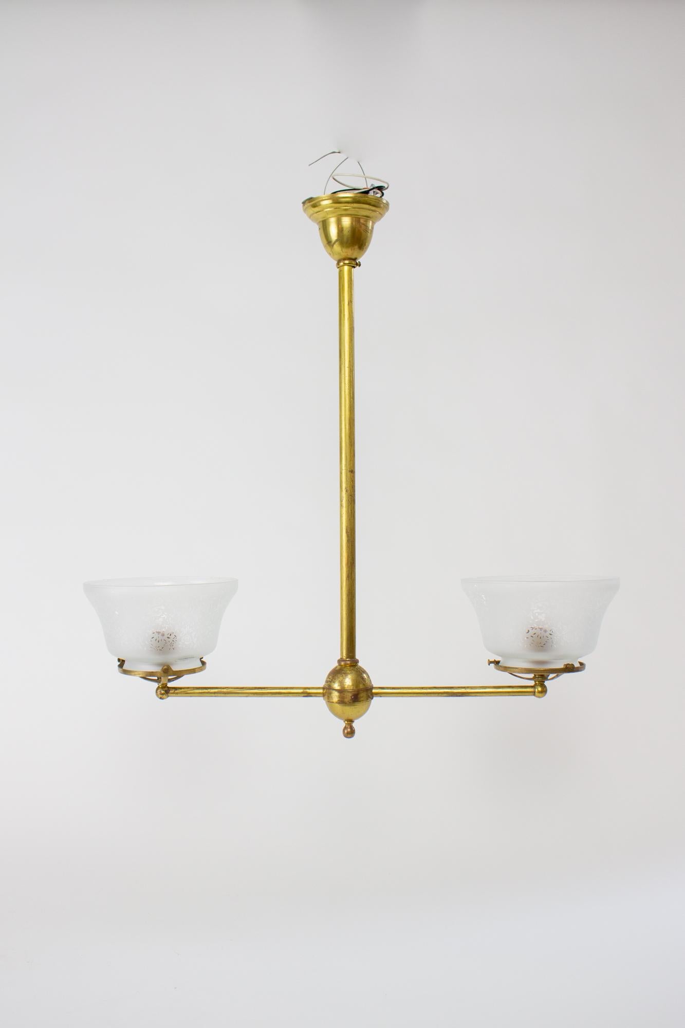 Two light Victorian fixture. Made during the transition to electric but with gas lighting parts. Original bell shaped canopy, with a straight tube down to the round central stem piece. Round tubing extends straight as two arms. The fixture is in a T