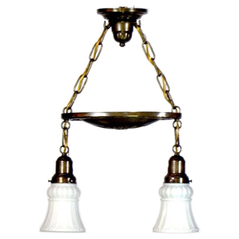 Piccolo apparecchio a due luci con vetro bianco opaco originale. C. 1915 Completamente restaurato e pulito, con patina di ottone antico. Ricablato e pronto per essere appeso.

Dimensioni: 
Altezza: 21,5
Larghezza (diametro): 16