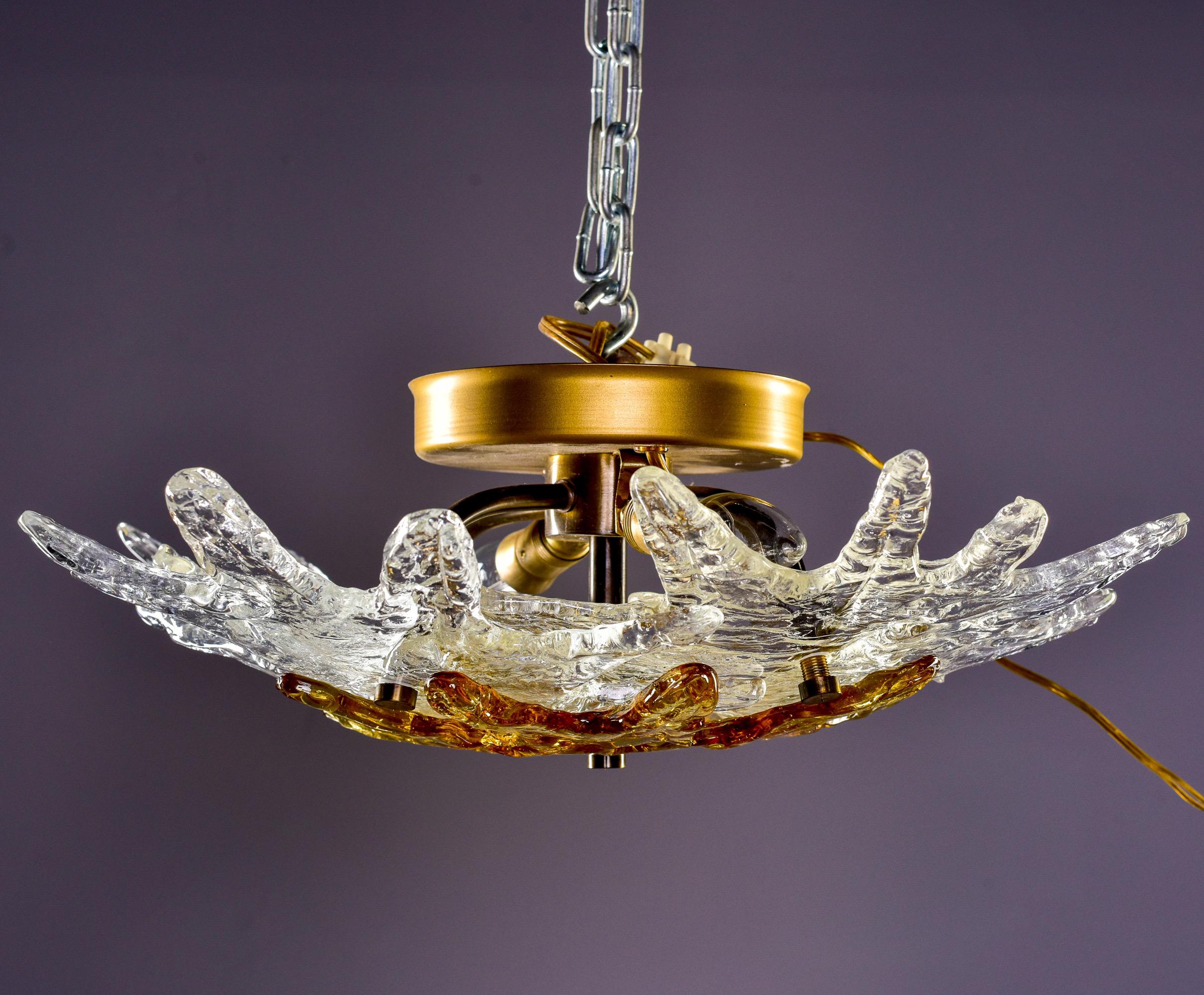 Circa 1960s flush light fixture by Italian maker Zero Quattro has two candelabra sockets covered with four sculptural stars in clear, heavy glass with an amber center star. New wiring for US electrical standards.