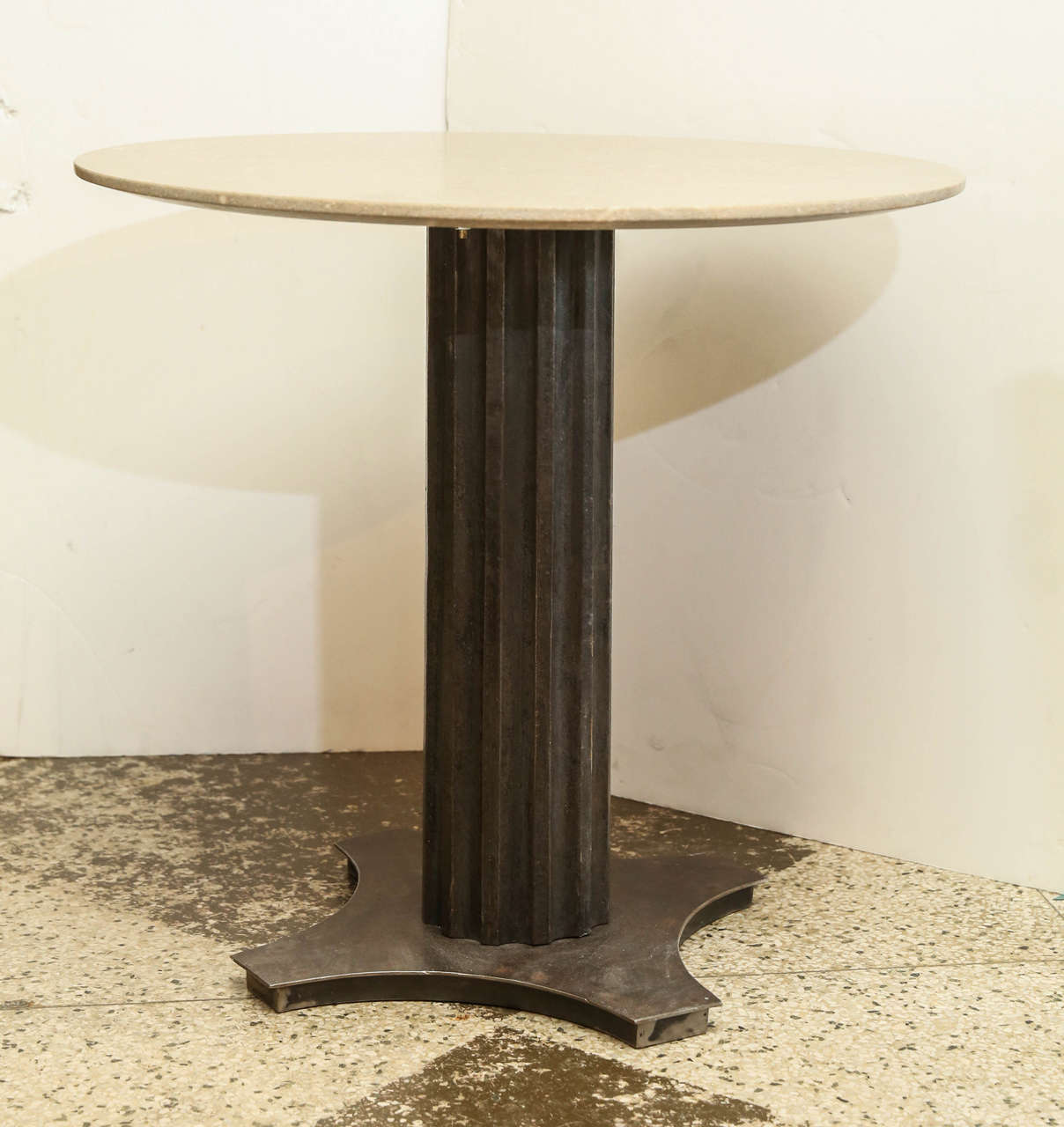 Two limestone top steel tables, newly honed round limestone tops raised upon antique cast steel fluted pedestals. Each side table sold individually priced $2,800 each.