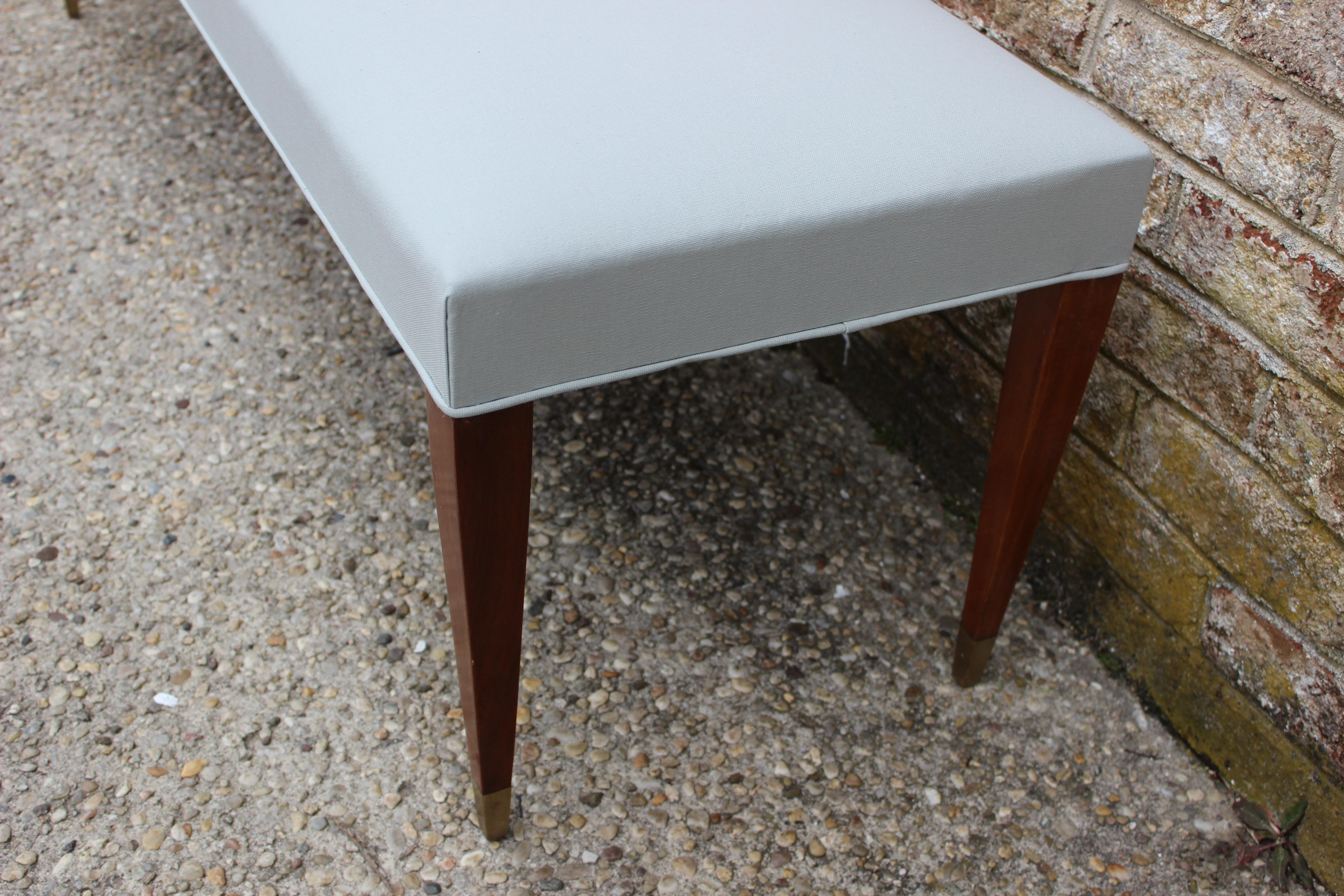 Long French Benches with tapered Mahogany wood legs and bronze sabots, newly upholstered Light Gray Sunbrella Fabric