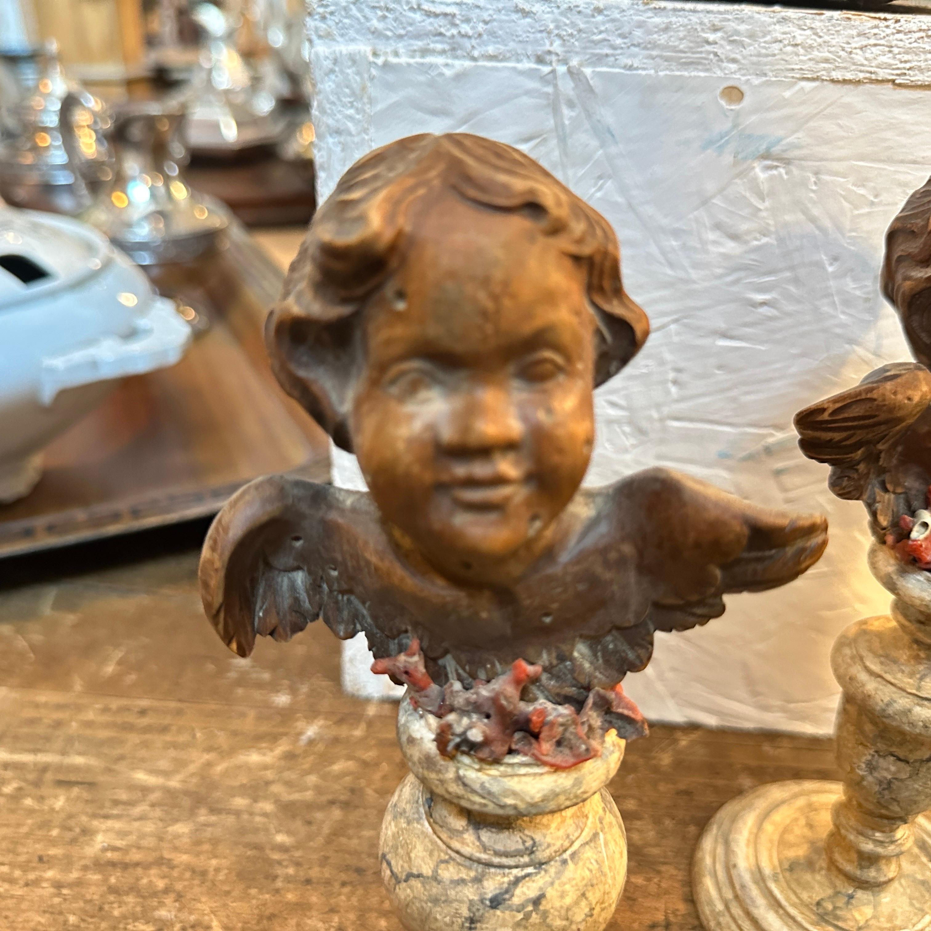 An exquisite pair of 19th-century Louis Philippe Sicilian wood angel figures. Each piece is meticulously hand-carved, capturing the serene and cherubic expressions of classic putti. The angels feature detailed facial expressions and outstretched