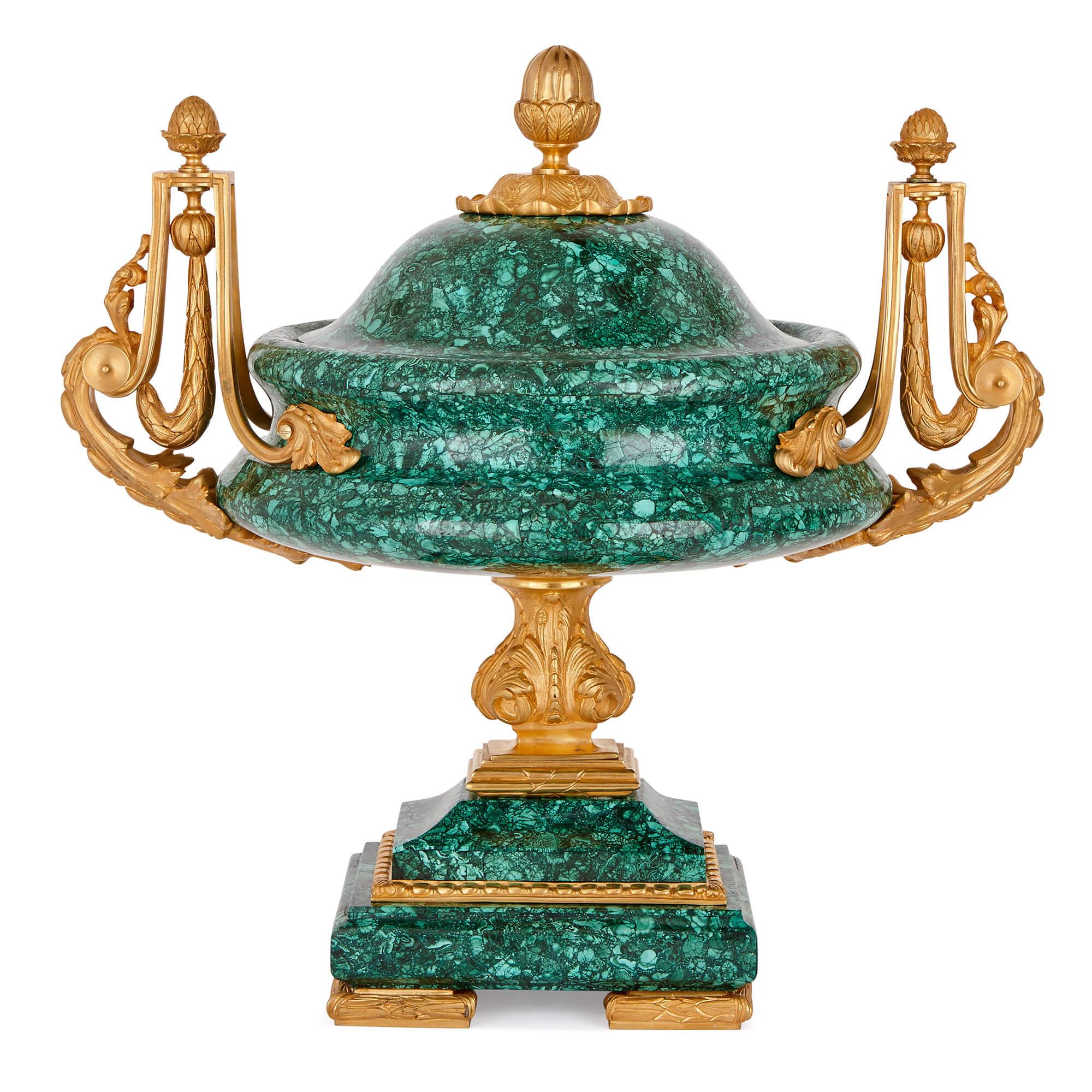 These vases are beautiful pieces of French design, originating from the late 19th Century, and more recently enhanced with vibrant veneers in the green gemstone, malachite.

The foot of each vase takes the form of a stepped malachite block, raised