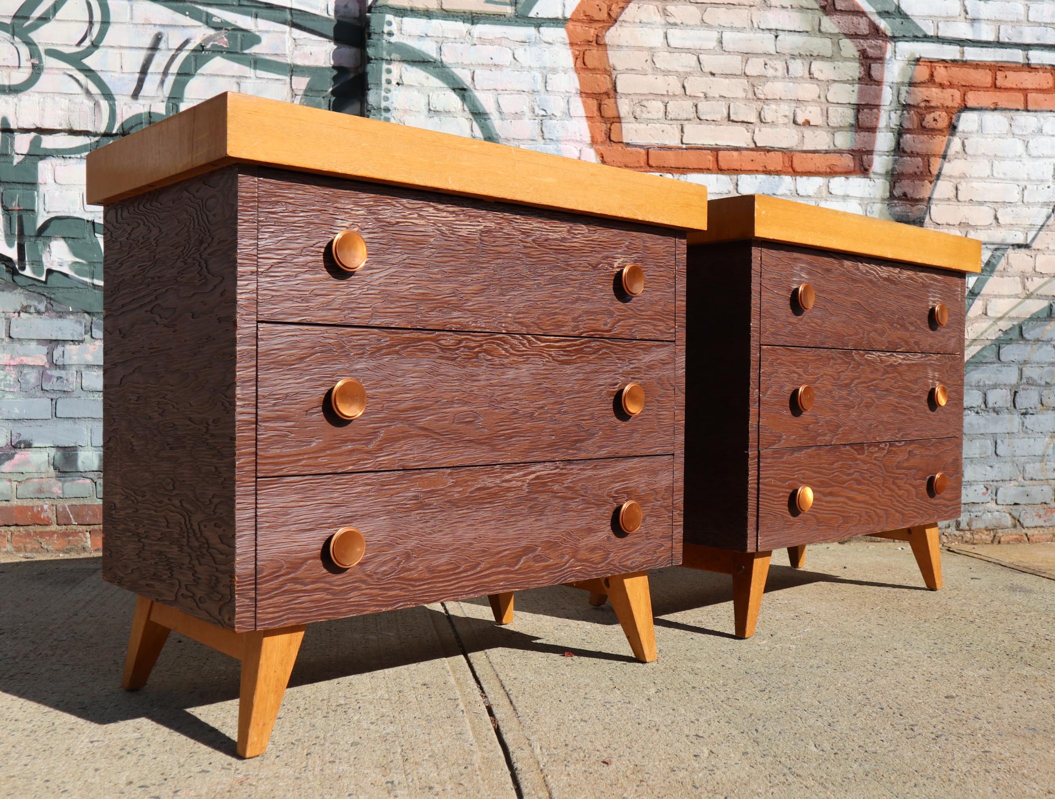 Unique statement pair of matching three-drawer dresser set. Textured drawer front and brass pulls. Blonde wood tops and darker bodies on blonde legs. Moderate wear.