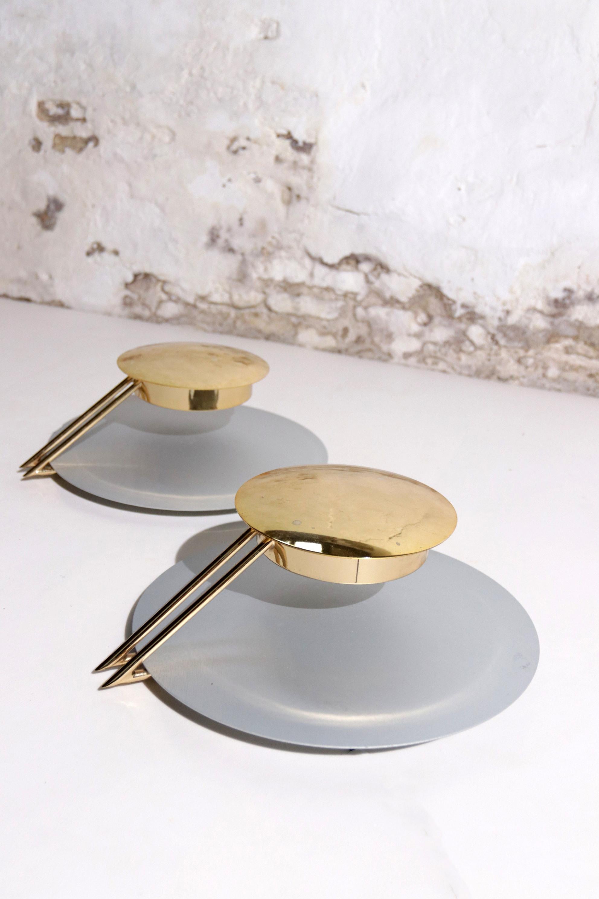 Two Memphis Style, Sleek design, wall lights or scones made by Tre Ci Luce Vega and designed by Luciano Cesaro & Fabio Amico 1985.
Silver metal round disc as back plate, brass arms and round brass top plate.

Tre Ci/Luce, literally translated as