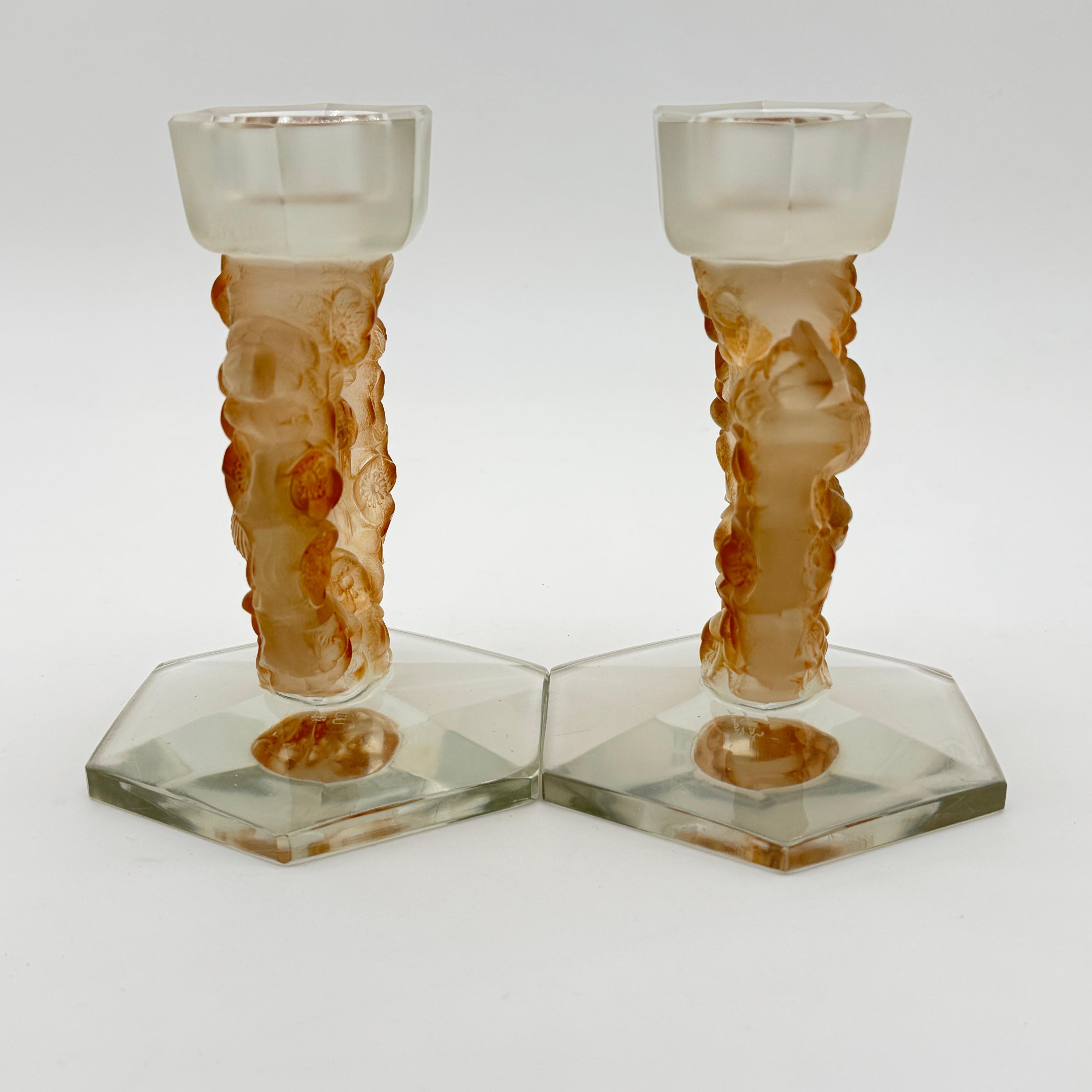 Die Kerzenständer Mésanges wurden 1943 von R. Lalique aus weißem Glas hergestellt.

Die Kerzenständer sind in ausgezeichnetem Zustand mit einer braunen Patina.

Sie sind in Schreibschrift und sandgestrahlten Blockbuchstaben handsigniert.

Sie sind