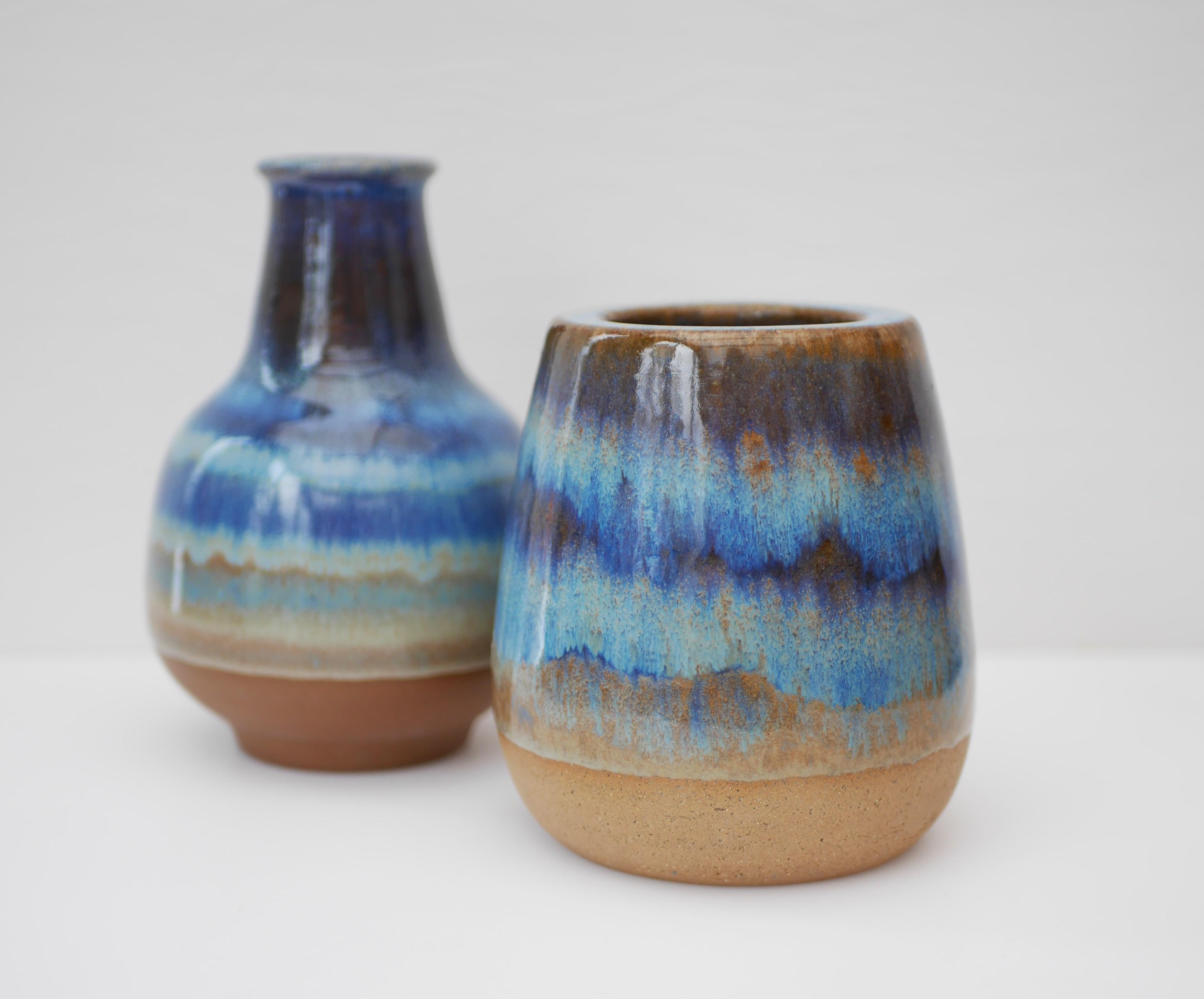 Two stunning vases by Micheal Andersen, Bornholm ceramics in Denmark. Heavy clay with a blue glaze that varies in color and intensity around the main body, on the rim and inside both pieces. The smaller one is 12.5cm (4.92