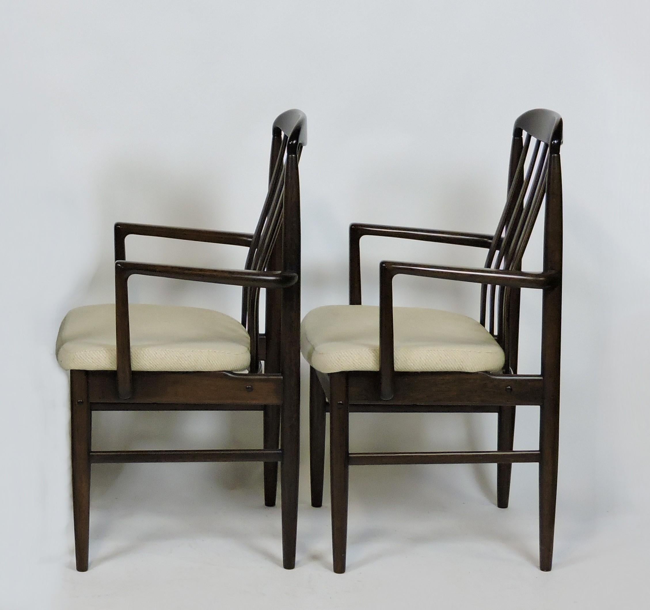 Set of two BL10A Sanne armchairs designed by Danish designer Benny Linden. These chairs are made of solid walnut with contoured spindle backs and upholstered seats in the original oatmeal colored fabric. Very comfortable chairs with a graceful look.