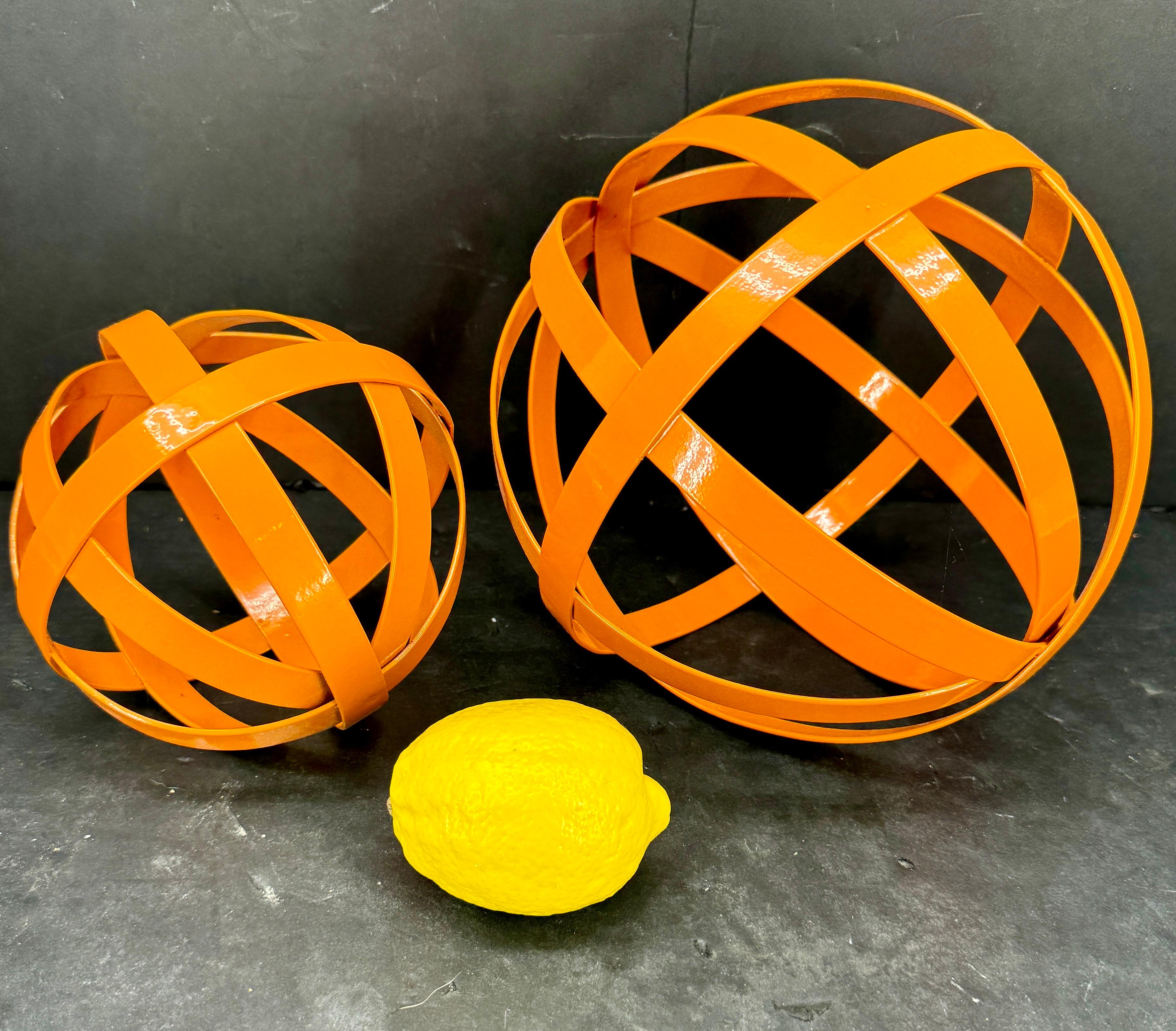 Palle decorative uniche nel loro genere, verniciate a polvere in una calda tonalità di arancione. Queste sculture rotonde aggiungeranno sicuramente un tocco di colore a qualsiasi console, tavolino o libreria.  