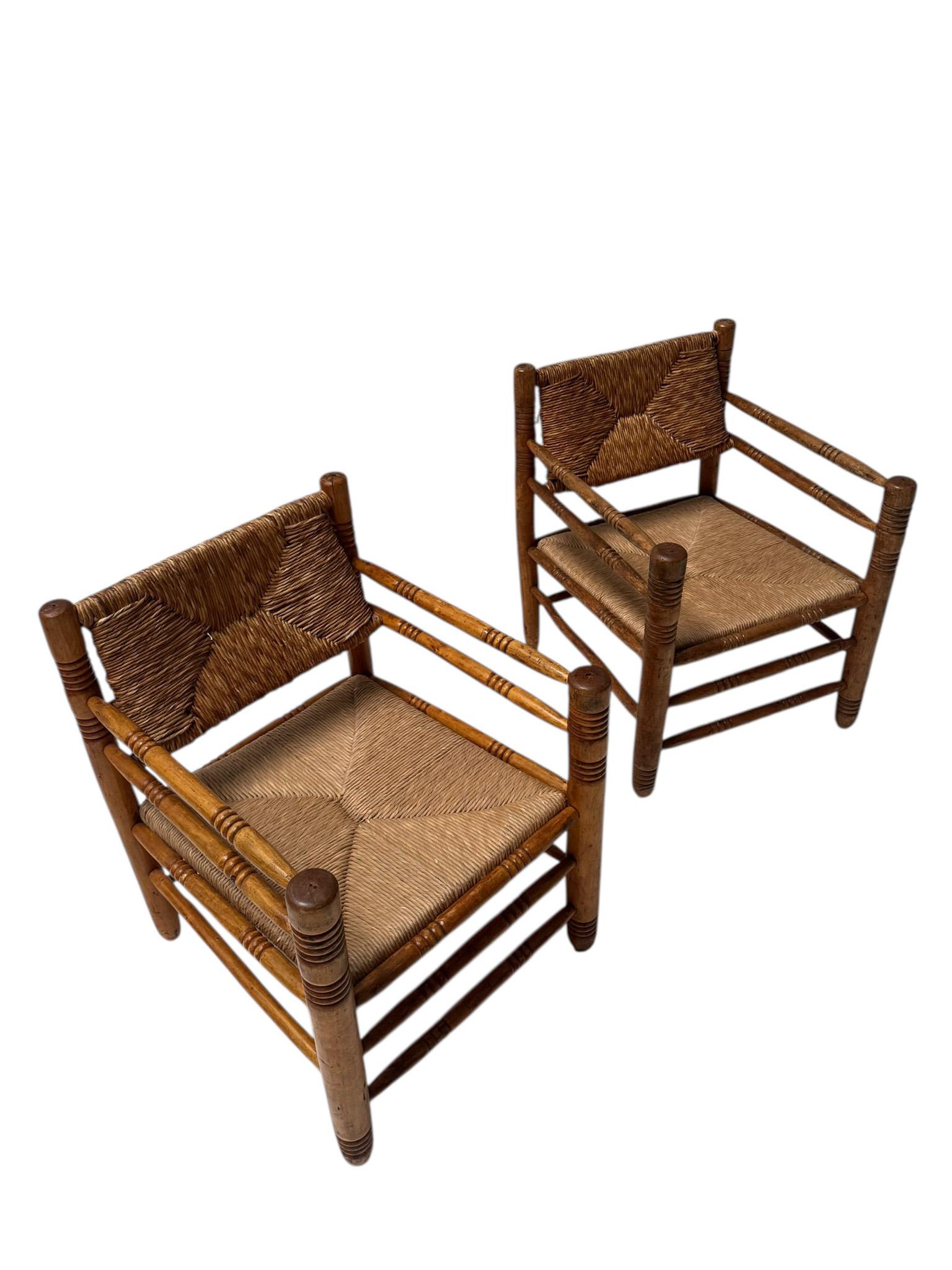 Stunning and elegant pair of Mid-Century Modern armchairs.
Design in the style of Audoux-Minet.
Striking French design from the 1950s.
Solid stained beech frames with original rush seats and backs.
This wonderful set of two Mid-Century Modern