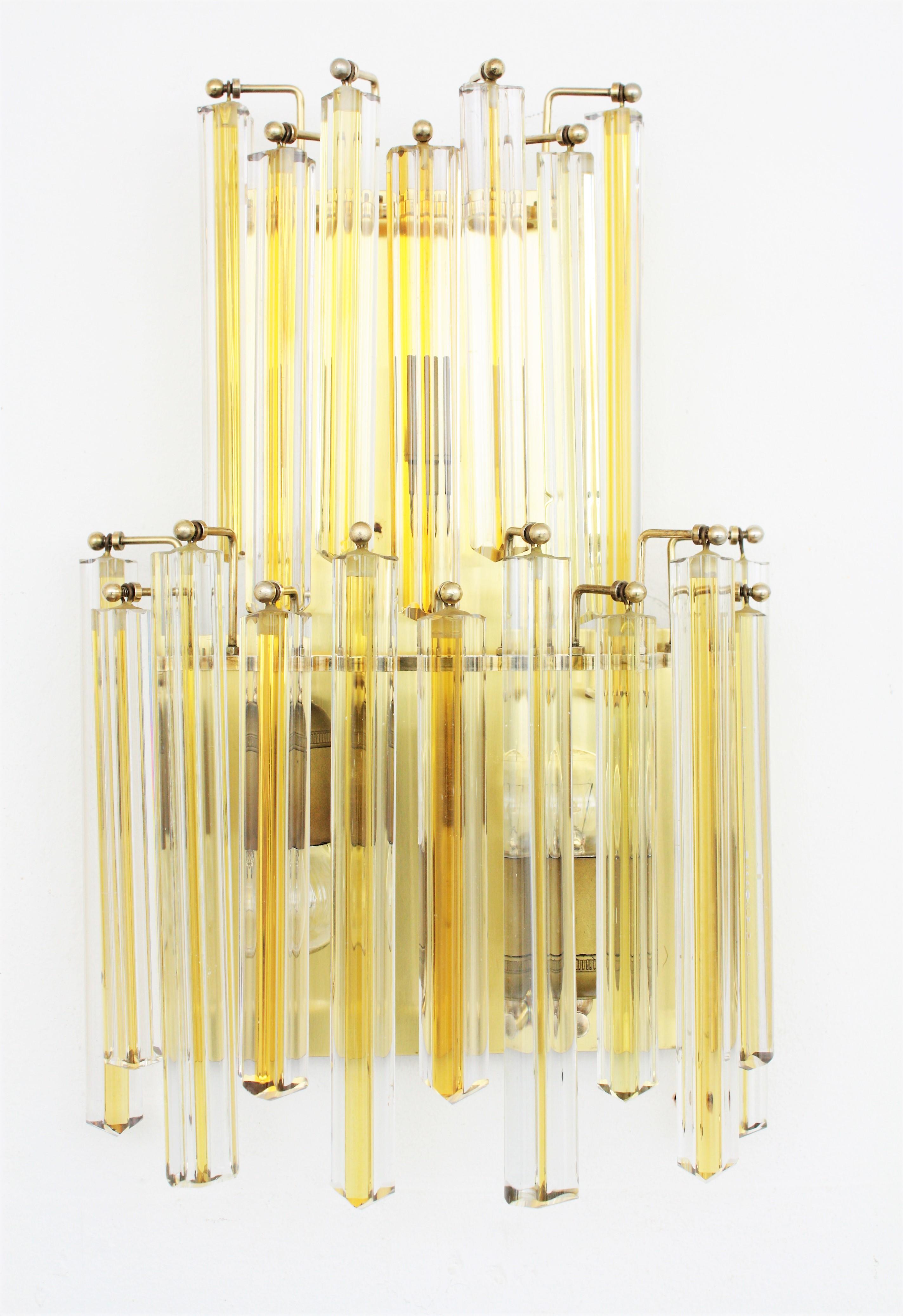 Unmatching Pair of Mid-century Modern two-light Murano glass wall sconces attributed to Venini. Italy, 1960s.
These wall lights are made with clear crystal triedri prysms with a yellow / amber filigree in the middle. The large one is made of 17