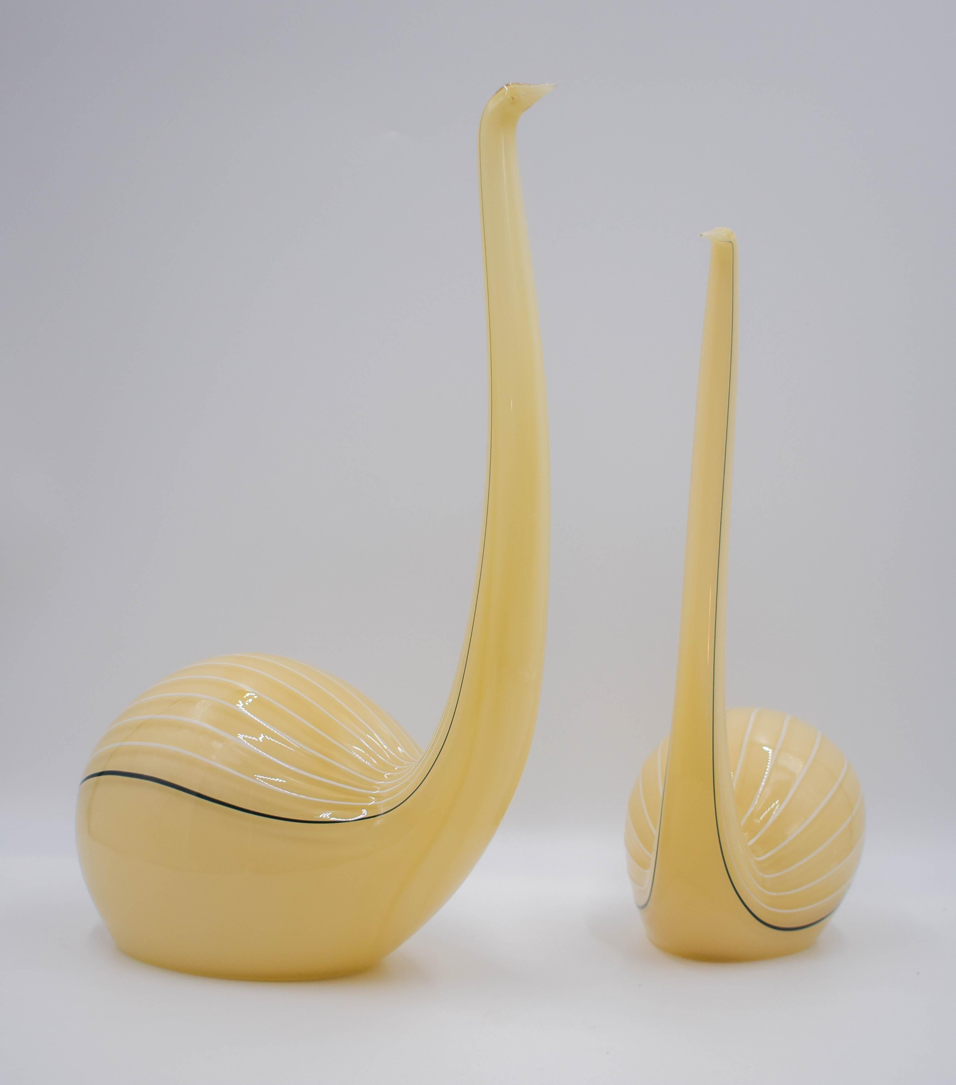 These two Seguso art glass bird sculptures are Classic midcentury Italian design from the Venetian island of Murano. Sleek with long necks and bulbous bodies, each is blown in custard colored glass white and brown decoration and signed. Both are in