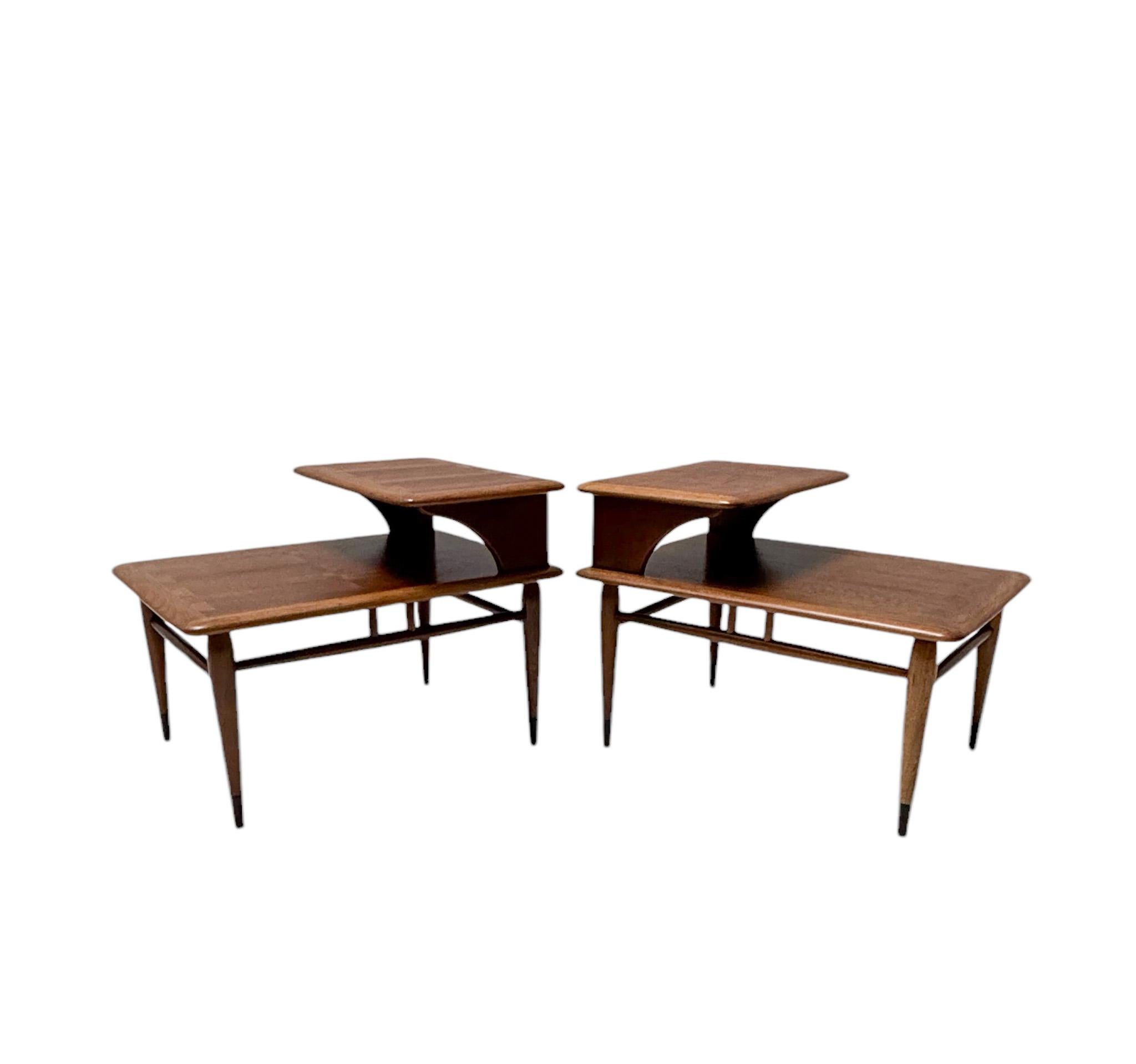 Stunning and rare pair of Mid-Century Modern two step end tables
Design by Andre Bus for Lane Acclaim Furniture.
Striking American design from the 1960s.
Solid walnut two tier end tables on brass wrapped tapered legs.
This wonderful pair of