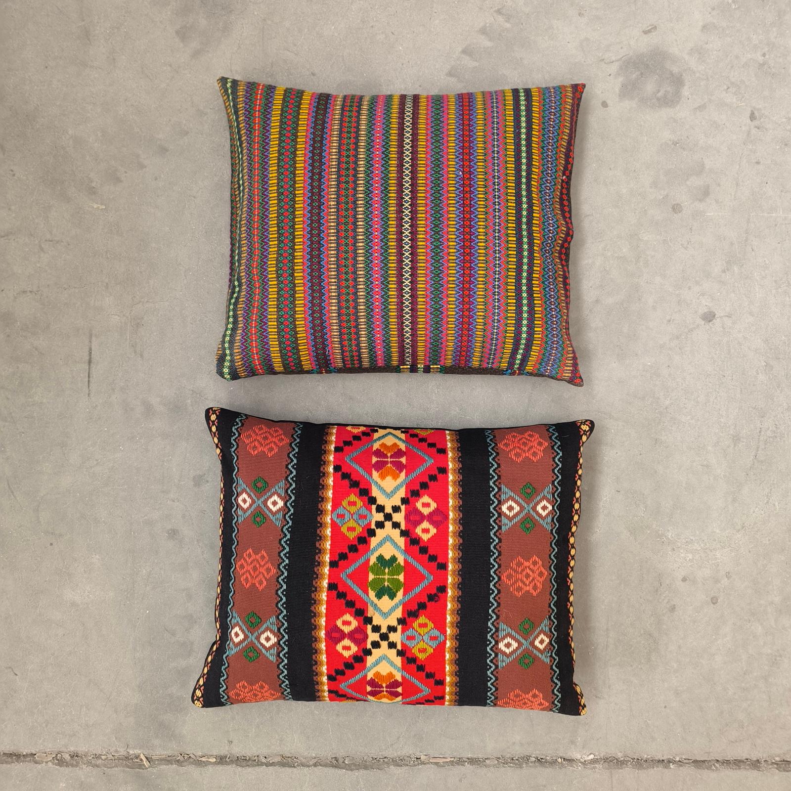 Celebra l'audace semplicità e la calda consistenza del design scandinavo con questa coppia vintage di cuscini d'arte popolare svedese, del 1950 circa. 
Ciascun cuscino offre una personalità distinta: uno presenta vibranti strisce orizzontali