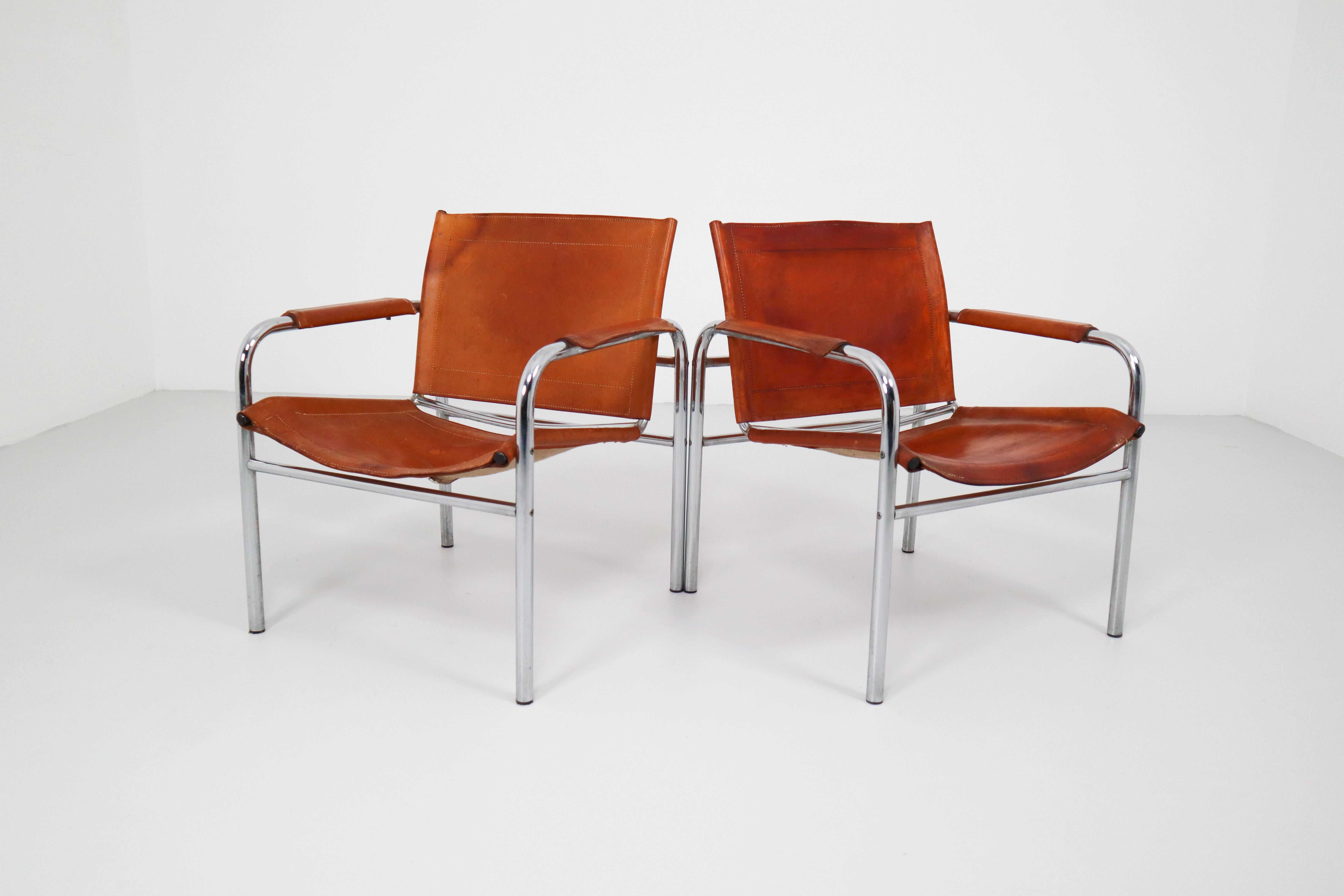 Set of two midcentury tubular chrome arm chairs with patinated cognac leather. An admirable patina is visible on the natural leather, which creates a vibrant surface and stunning color.
       