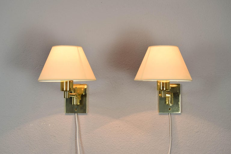 Set of two wall lamps designed by George W. Hansen in the 1960s and produced by the Spanish firm Metalarte with permission from Hansen Lamps New York in the 1970s. Brass structure and simple adjustable arm. They present areas with wear of the brass