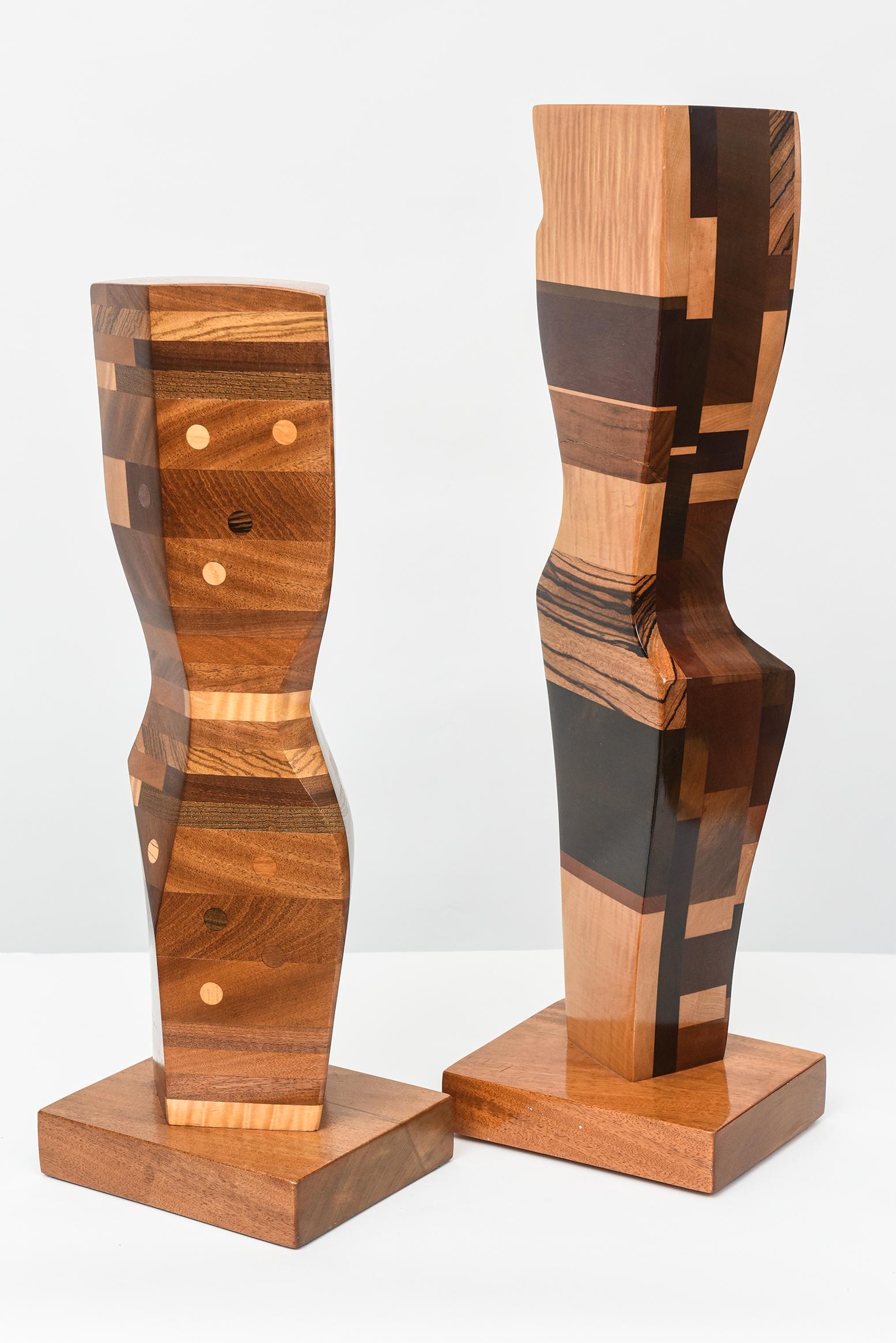 Two signed 1980s modern abstract sculptures by Paul LaMontagne, composed of stacked laminated and inlaid exotic woods. Priced and sold individually. Two available. 
Tallest: 28