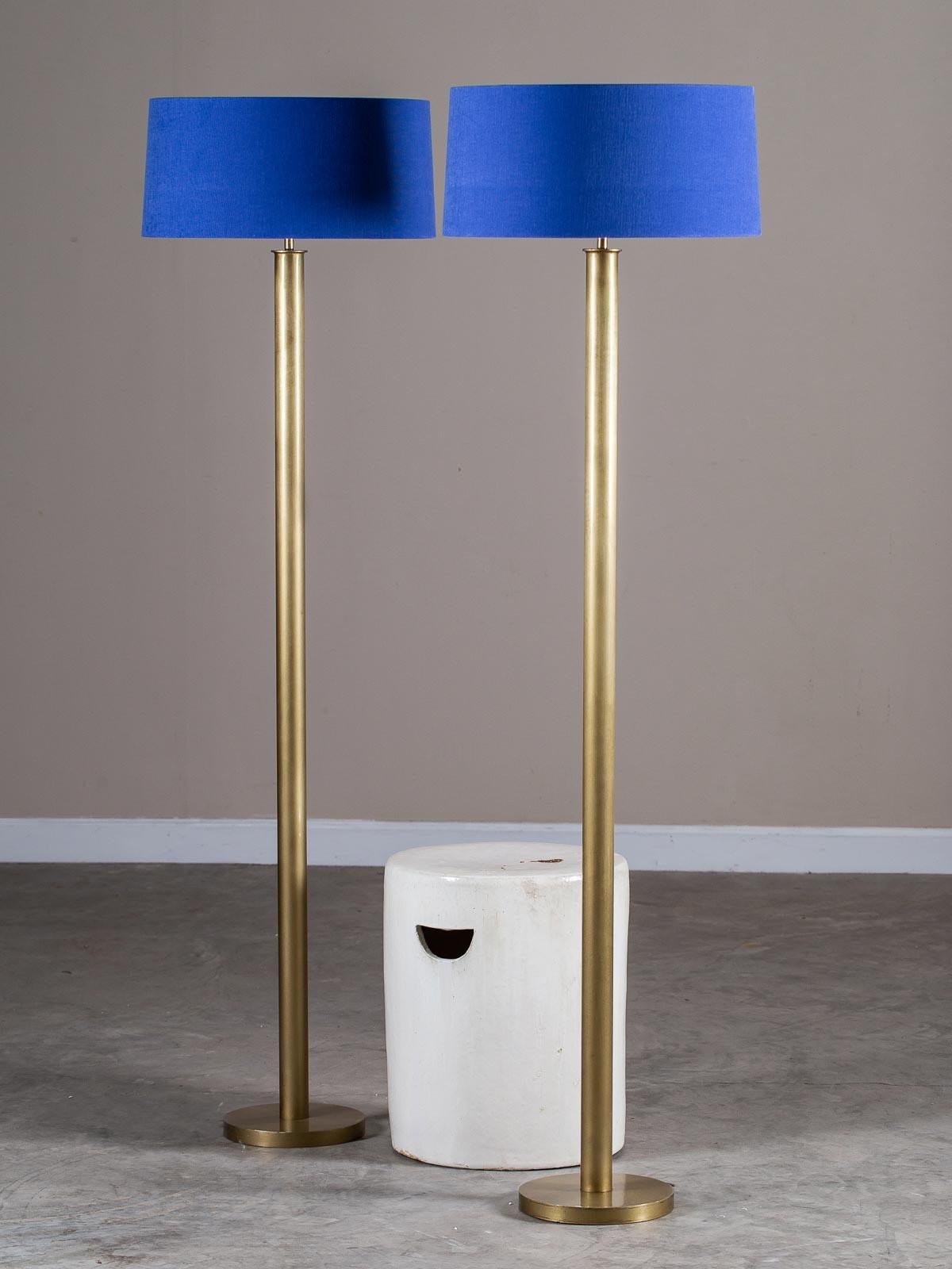 We love the utter simplicity of these modern brass floor lamps from Holland with their custom-made Delft blue linen contemporary shades. The circular base of each lamp supports a circular column with straight sides before reaching the European