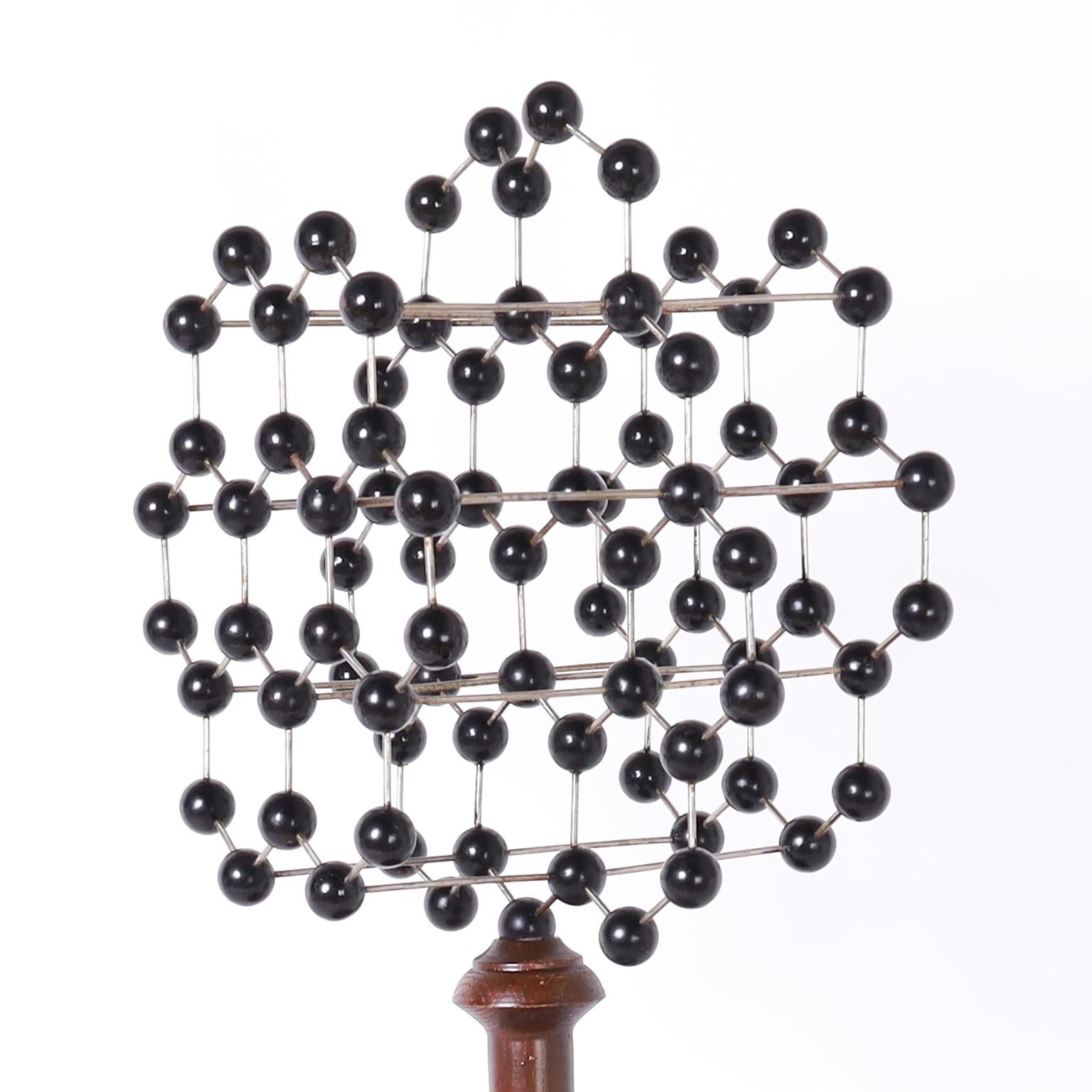 Academic style molecular structure model crafted with painted wood balls strung with metal rods and presented on a classic turned wood base. 
