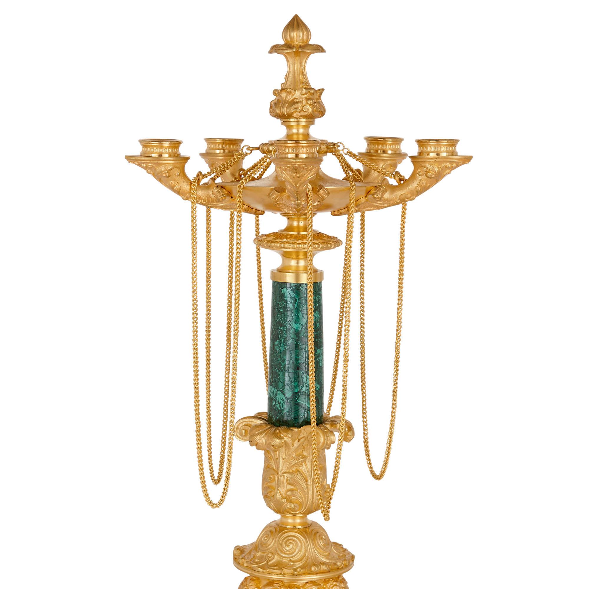 Two neoclassical early 19th century malachite and gilt bronze candelabra
French, circa 1830
Dimensions: Height 68cm, diameter 25cm

This superb pair of Charles X period candelabra is designed in the distinct Neoclassical style, crafted from