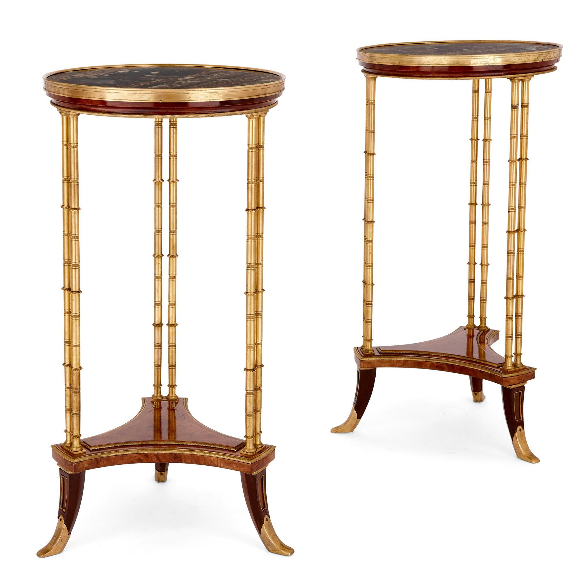 These beautiful circular side tables (French: guéridons) have been crafted from the finest materials, including marble, gilt bronze (ormolu) and mahogany wood. The tables are designed in a refined neoclassical style which is associated with the
