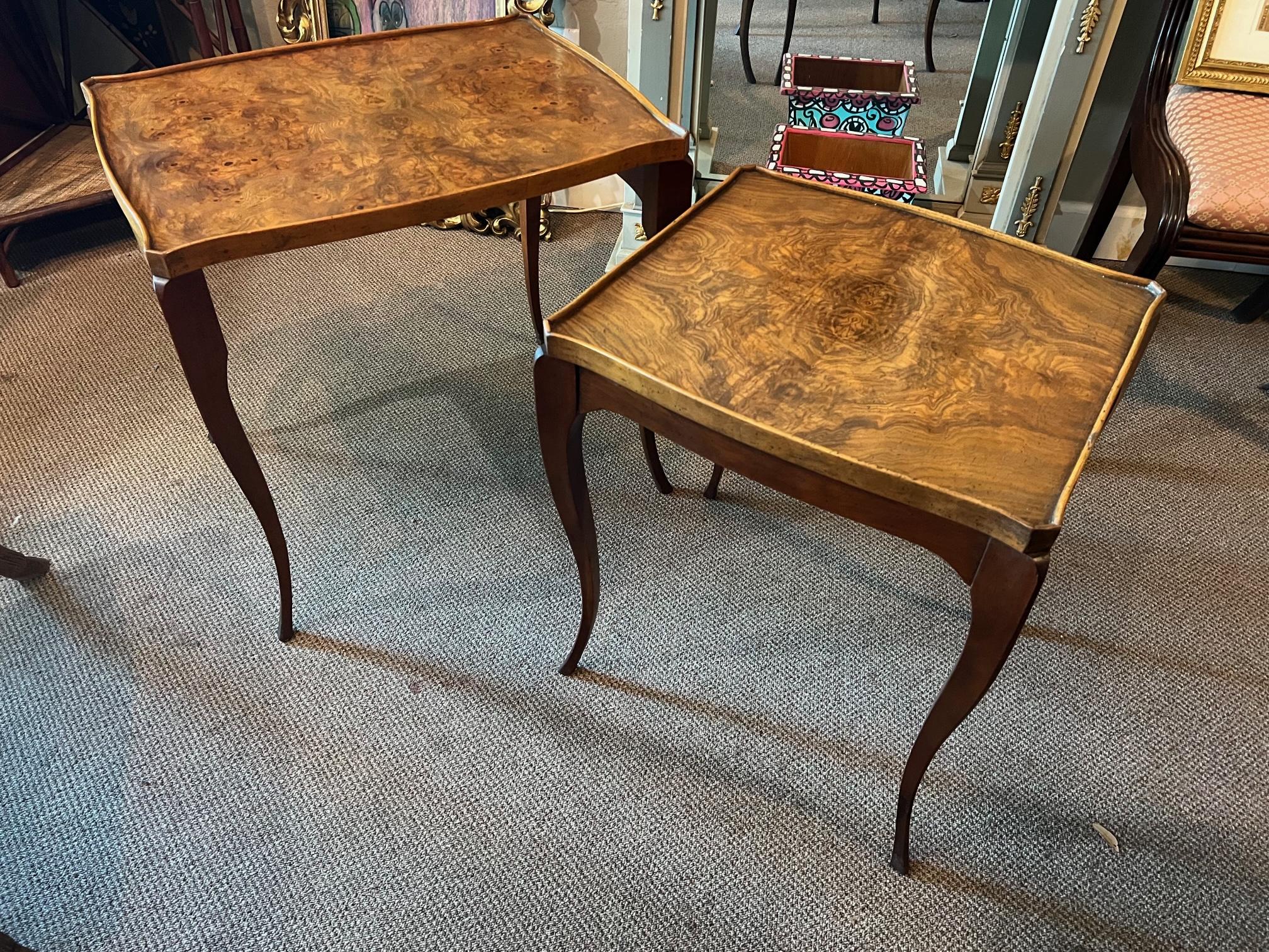 Two elegant nesting tables by Baker Furniture, ca' 1960's. Beautiful bookmatched, elmwood tops with raised edge. Cabriolet legs with original speckled finish.