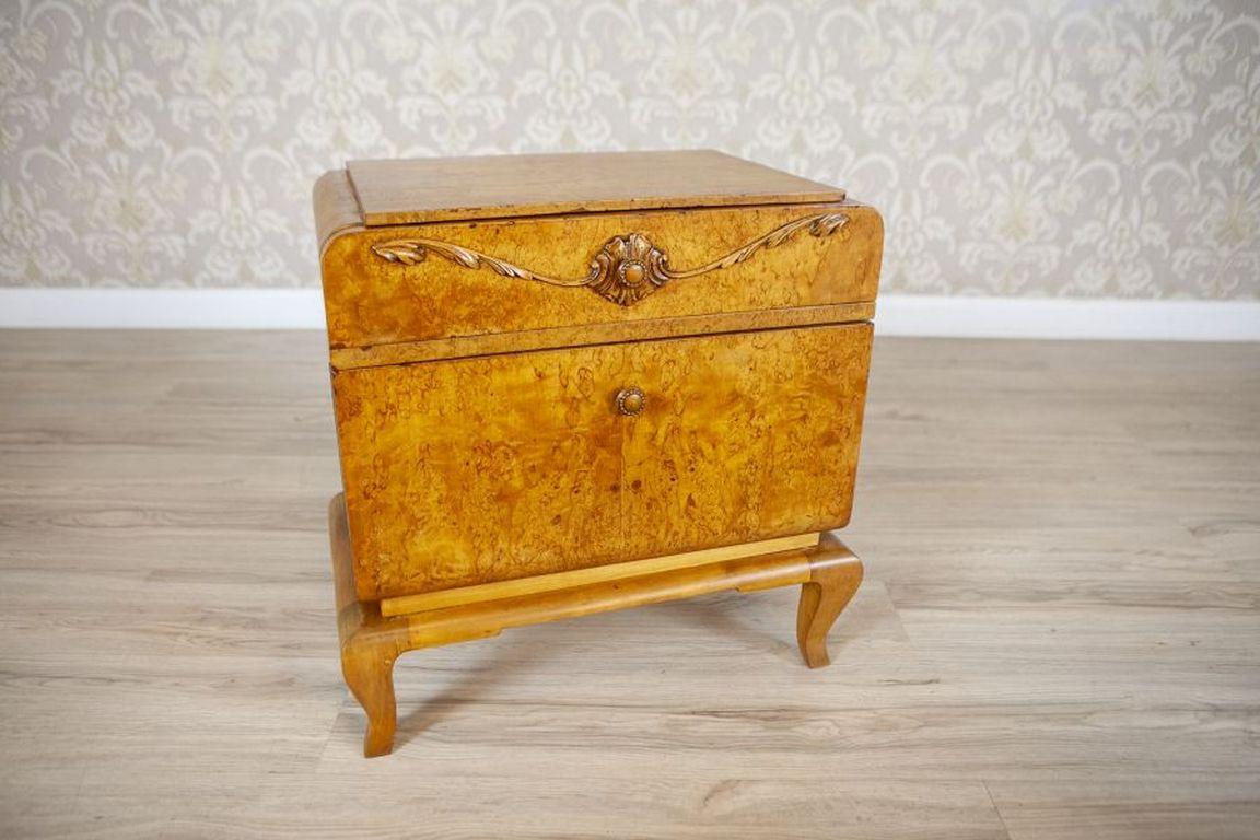 Two Nightstands From the Early 20th Century Veneered With Karelian Birch

A pair of two antique nightstands from the early 20th century, veneered with Karelian birch. Elegant in their simplicity, they feature opening doors and a drawer adorned with
