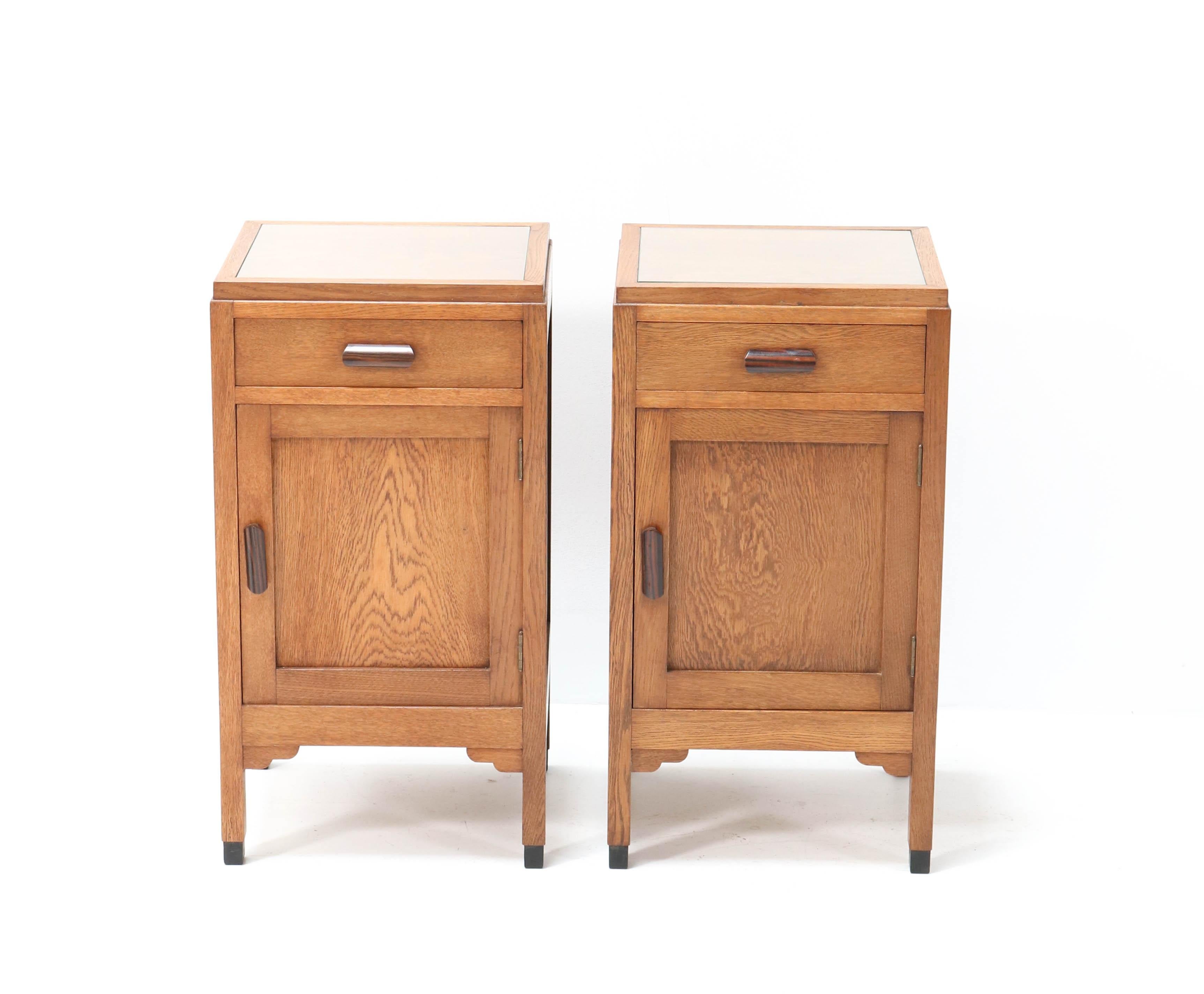 Wonderful and rare pair of Art Deco Amsterdam School nightstands or bedside tables.
Design by Fa. Drilling Amsterdam.
Striking Dutch design from the 1920s.
Solid oak with original solid Macassar ebony handles.
In very good condition with a