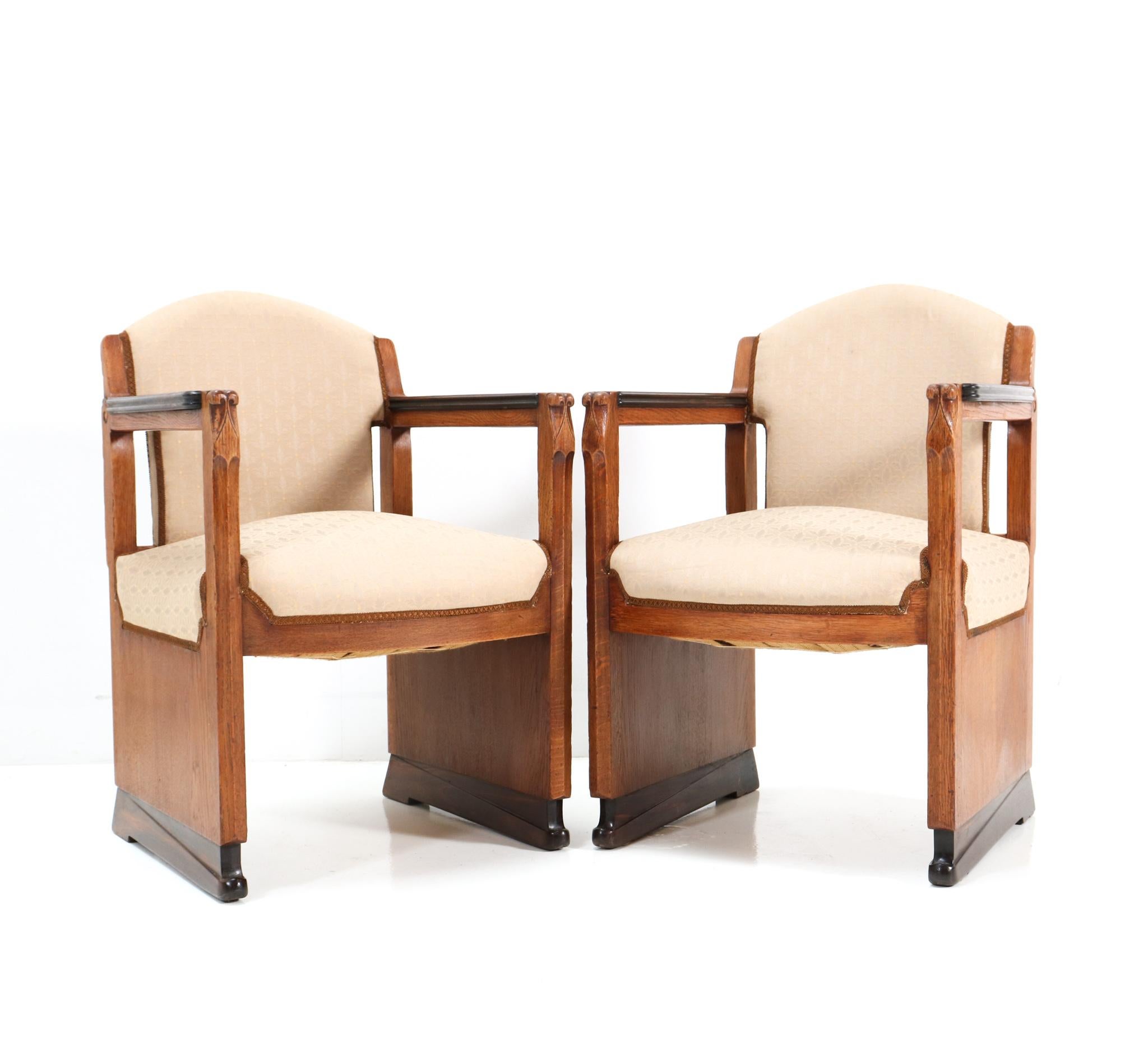 Magnificent and rare pair of Art Deco Amsterdamse School armchairs.
The design is attributed to Hildo Krop for 't Woonhuys Amsterdam.
Striking Dutch design from the 1920s.
Solid oak and original oak veneer base with solid macassar ebony